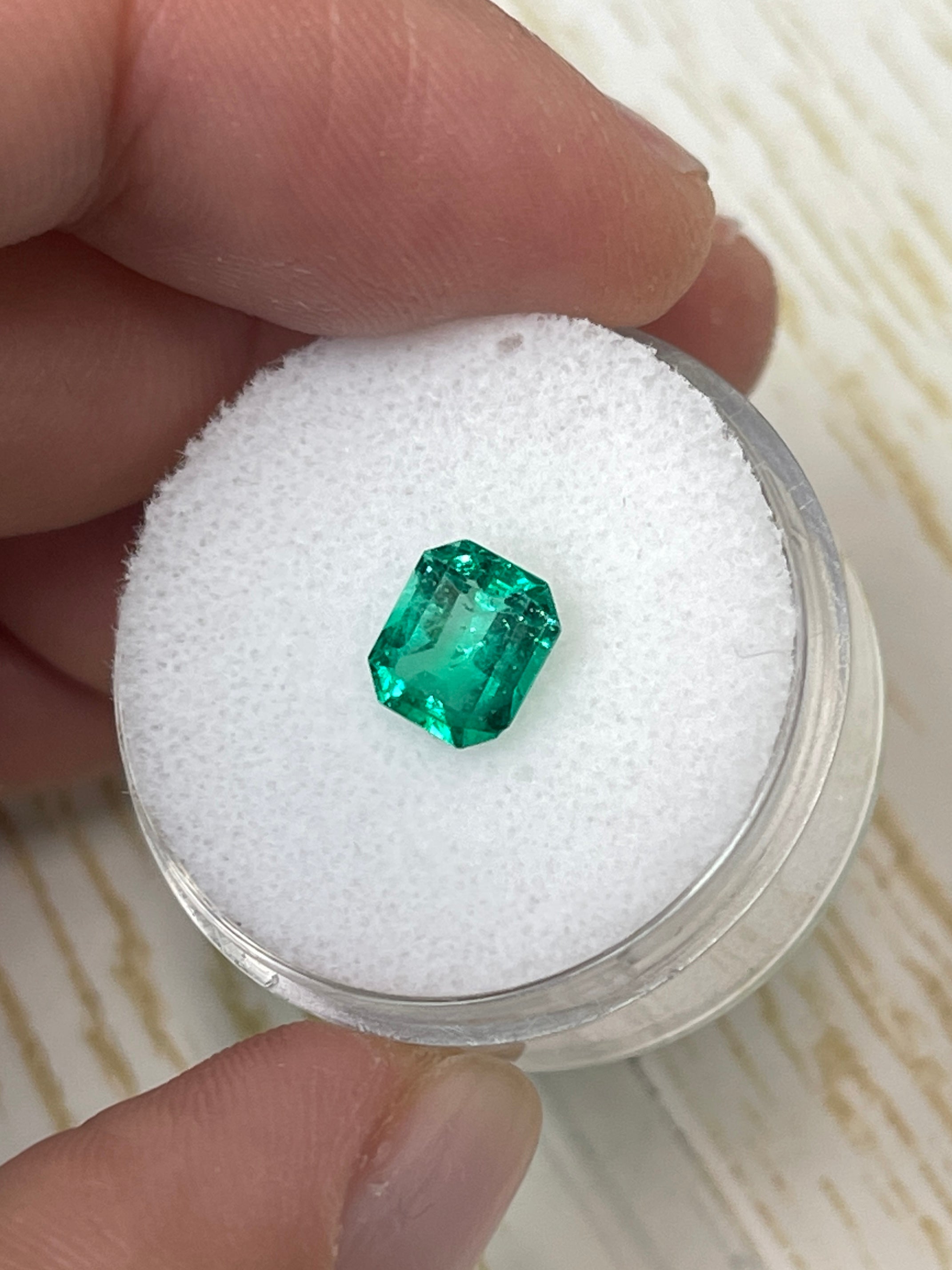 Loose 1.20 carat yellowish green Colombian emerald in an emerald cut, showcasing natural color and clarity, from JR Colombian Emeralds.