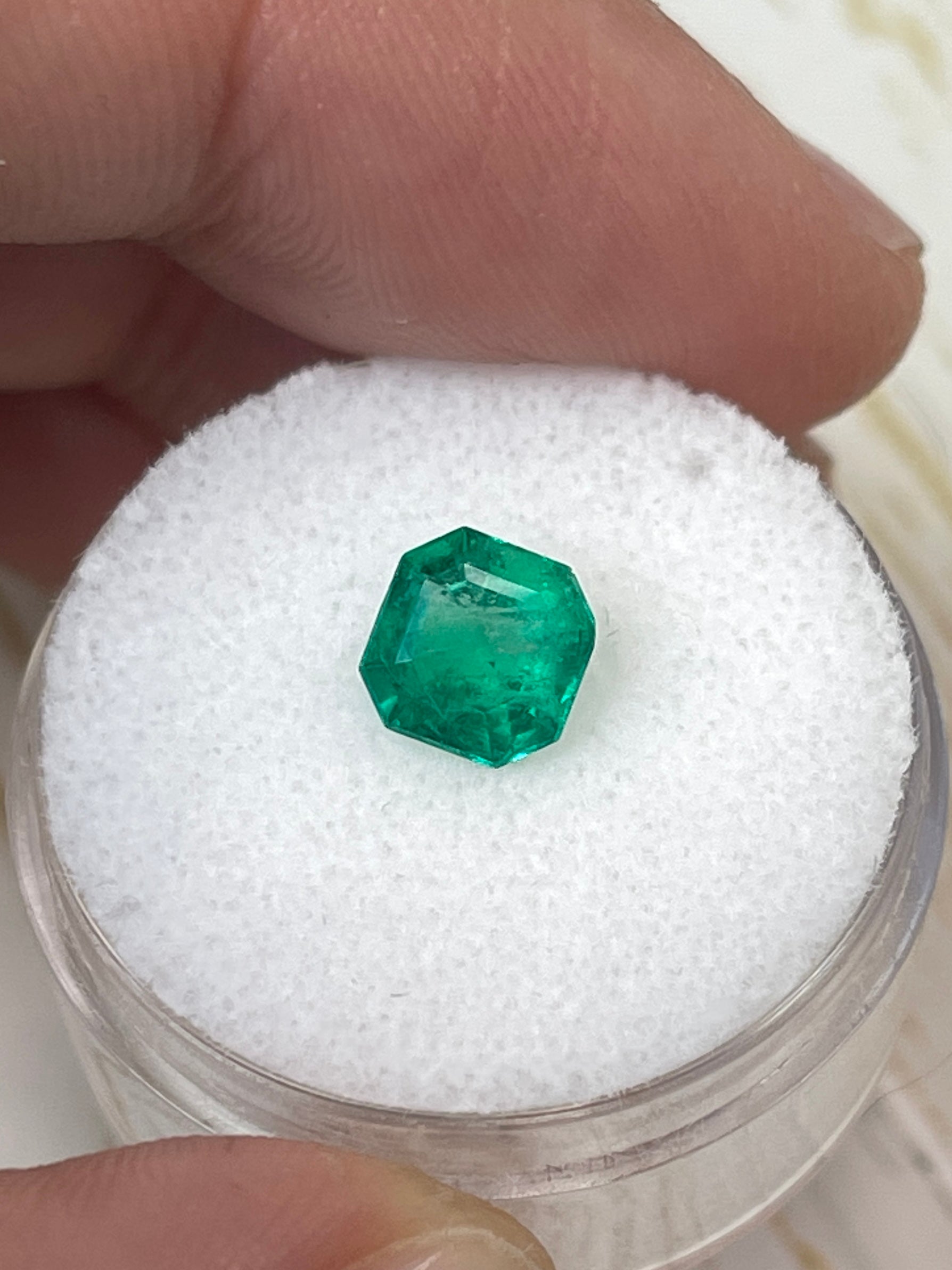 Bluish green 1.24 carat Asscher cut Colombian emerald, natural, unset gemstone with precise facets and vibrant color.