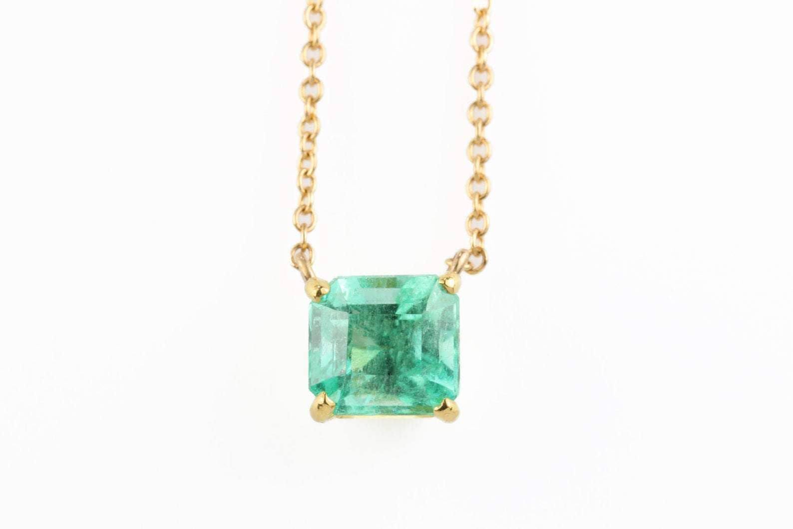 14K Colombian emerald necklace featuring a 1.30 carat rich green emerald cut solitaire pendant.