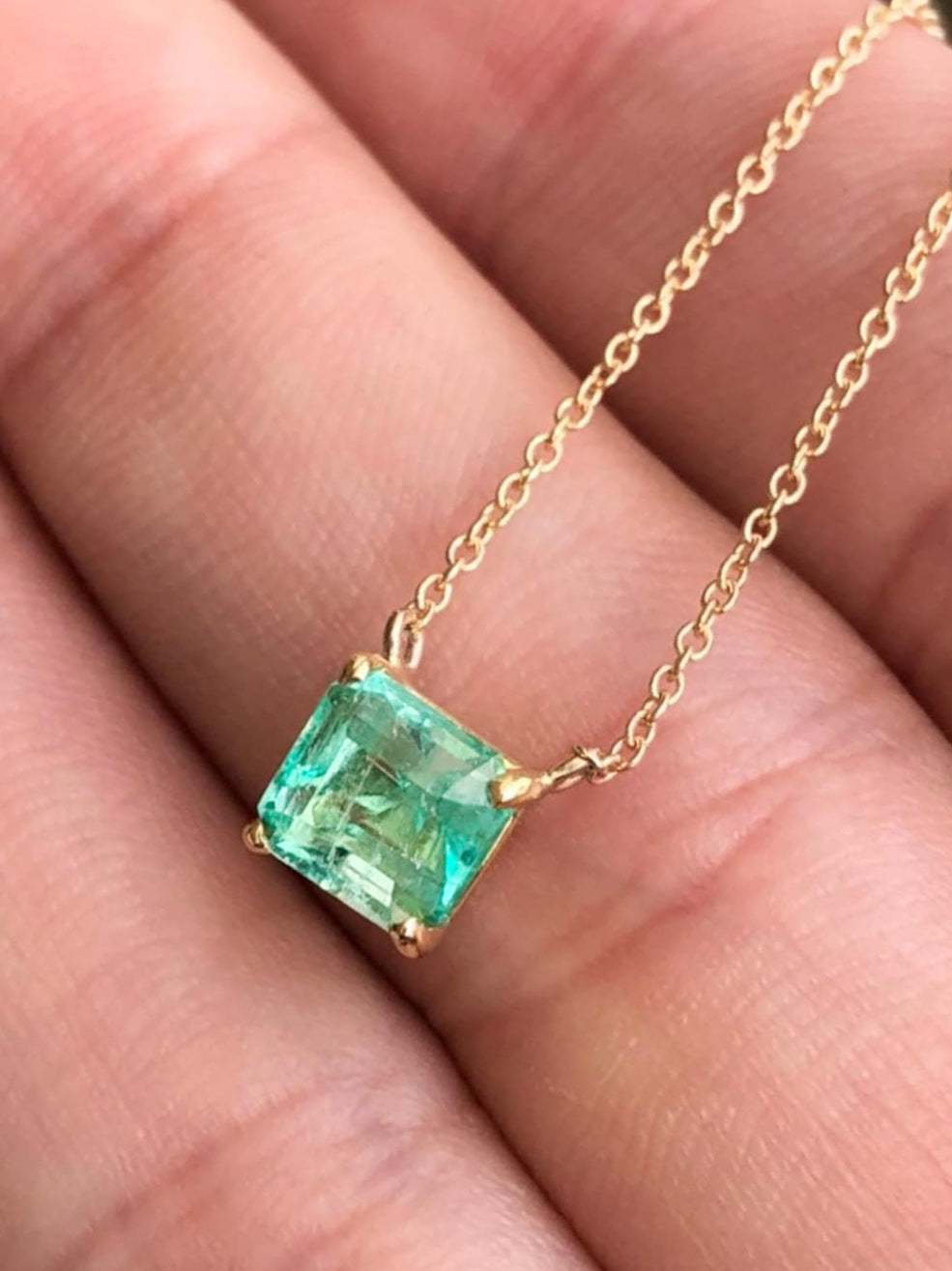 14K gold necklace with a 1.30 carat rich green Colombian emerald solitaire in an emerald cut.