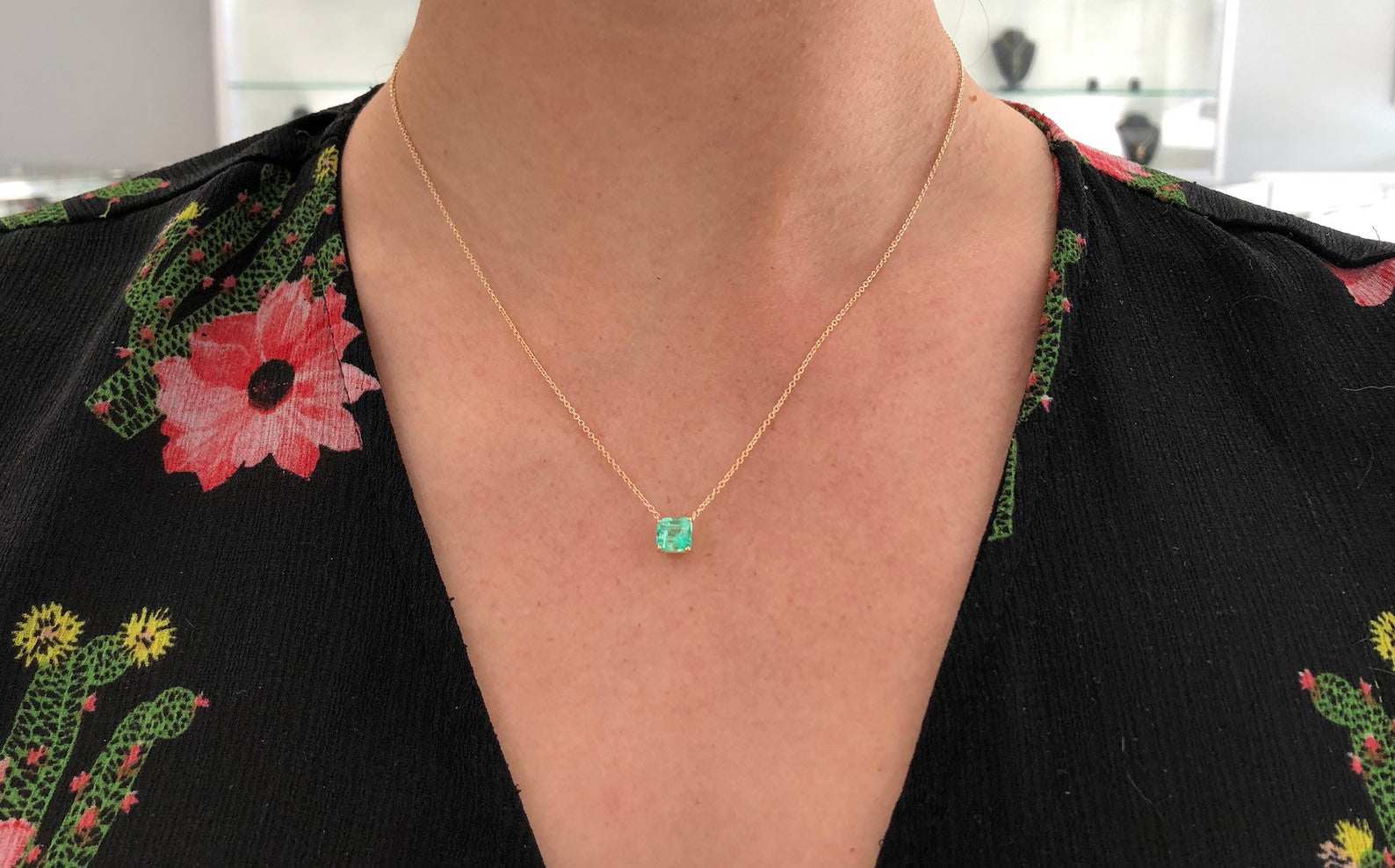 14K Colombian emerald necklace featuring a 1.30 carat rich green emerald in an emerald cut, showcased on a delicate chain.