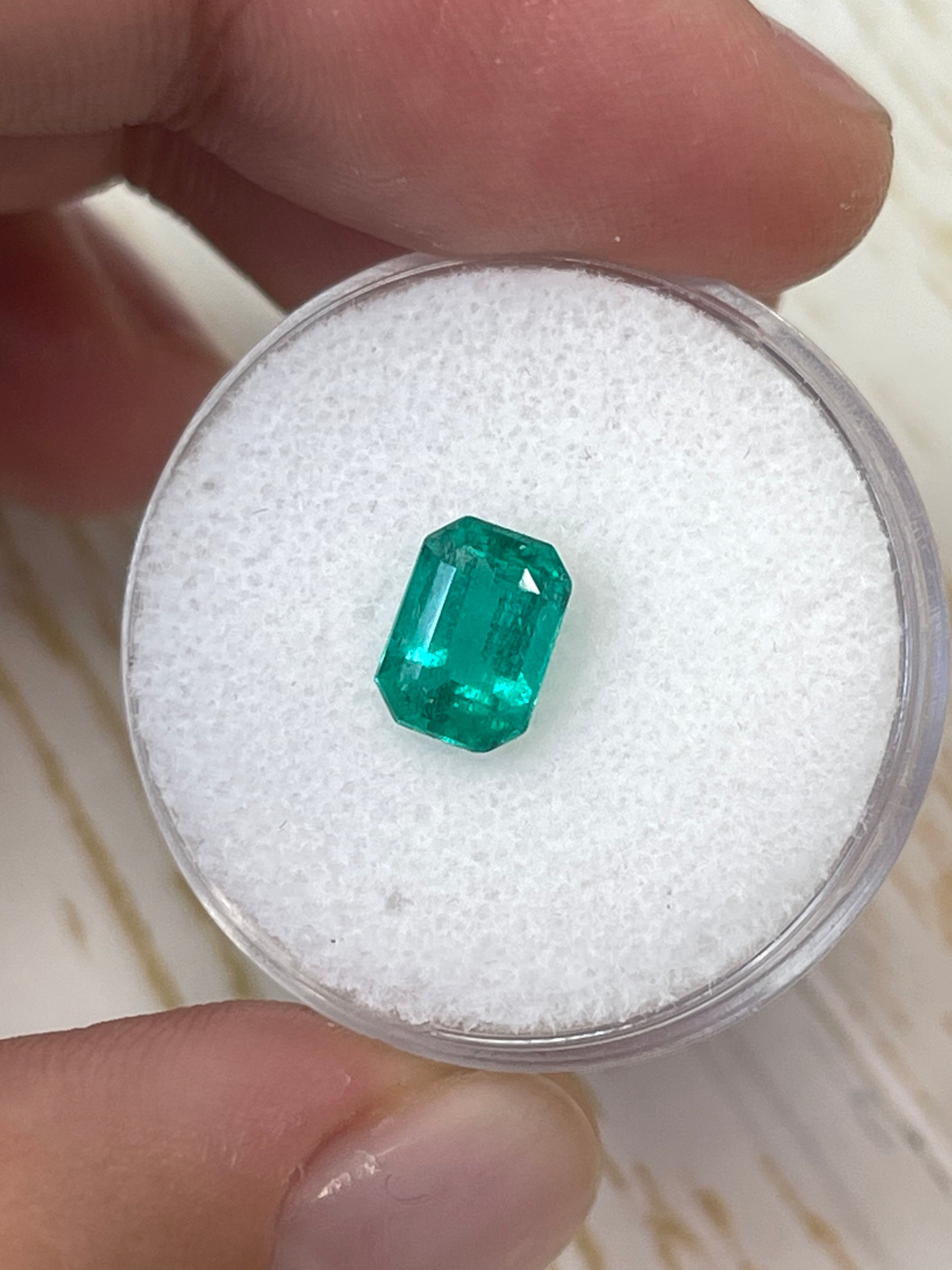 Loose 1.31 carat Colombian emerald in an 8x6 emerald cut, showcasing vibrant green color and clarity from JR Colombian Emeralds.