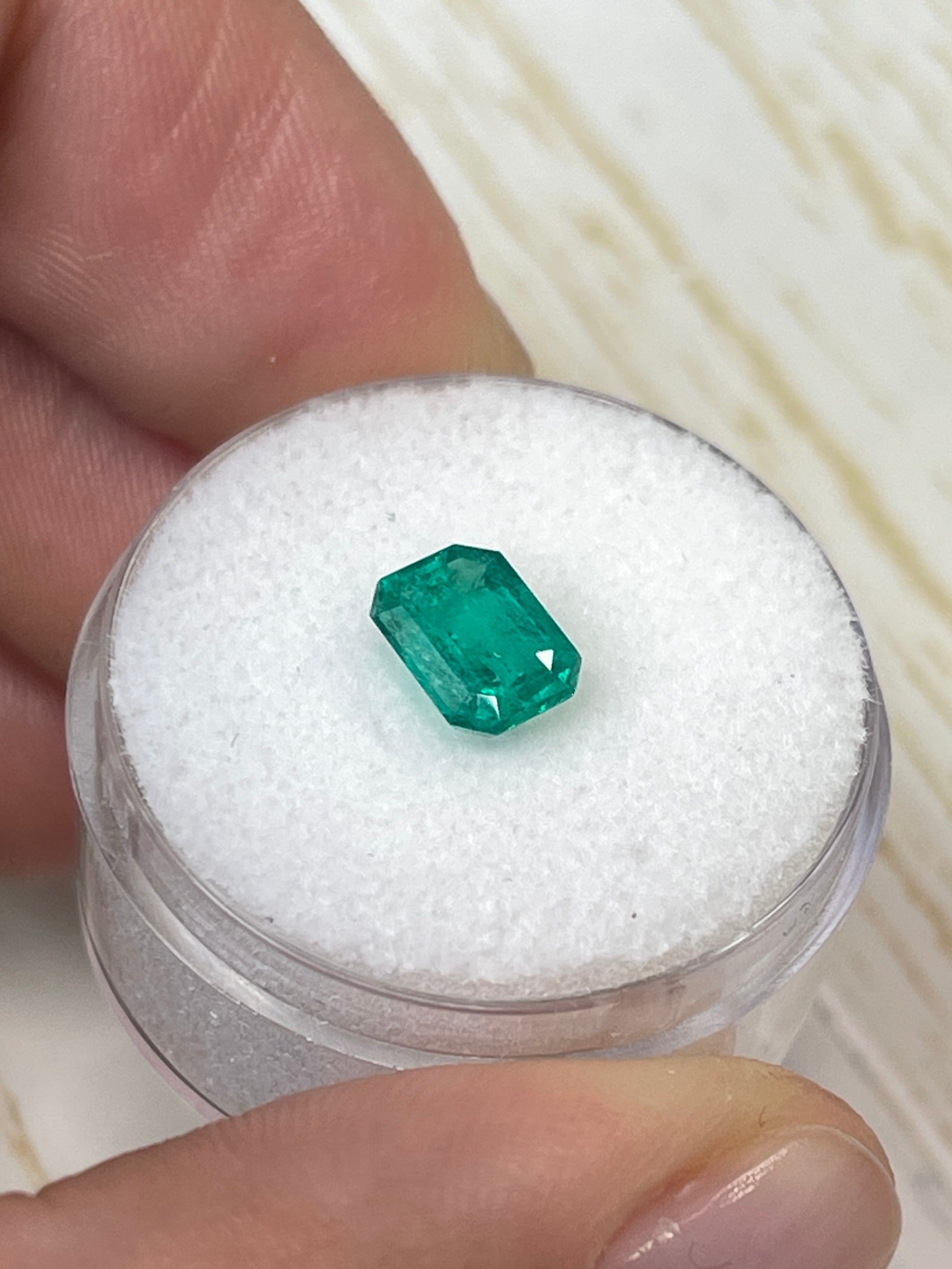 Loose 1.31 carat Colombian emerald cut gemstone with vibrant green color, showcasing clarity and fine craftsmanship.