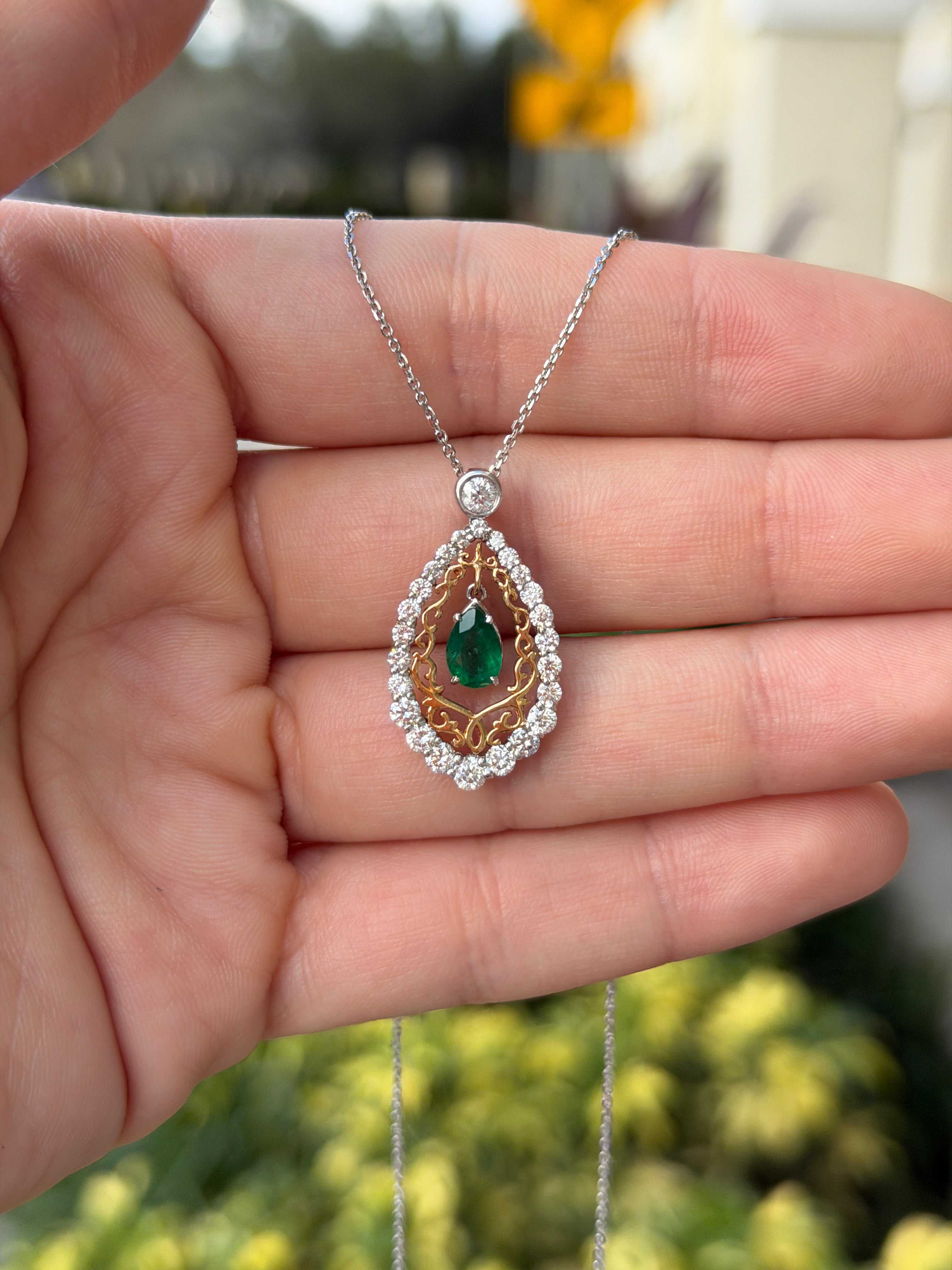 Pear emerald and diamond statement necklace with 14K two-tone gold, featuring elegant gemstone and metal design.