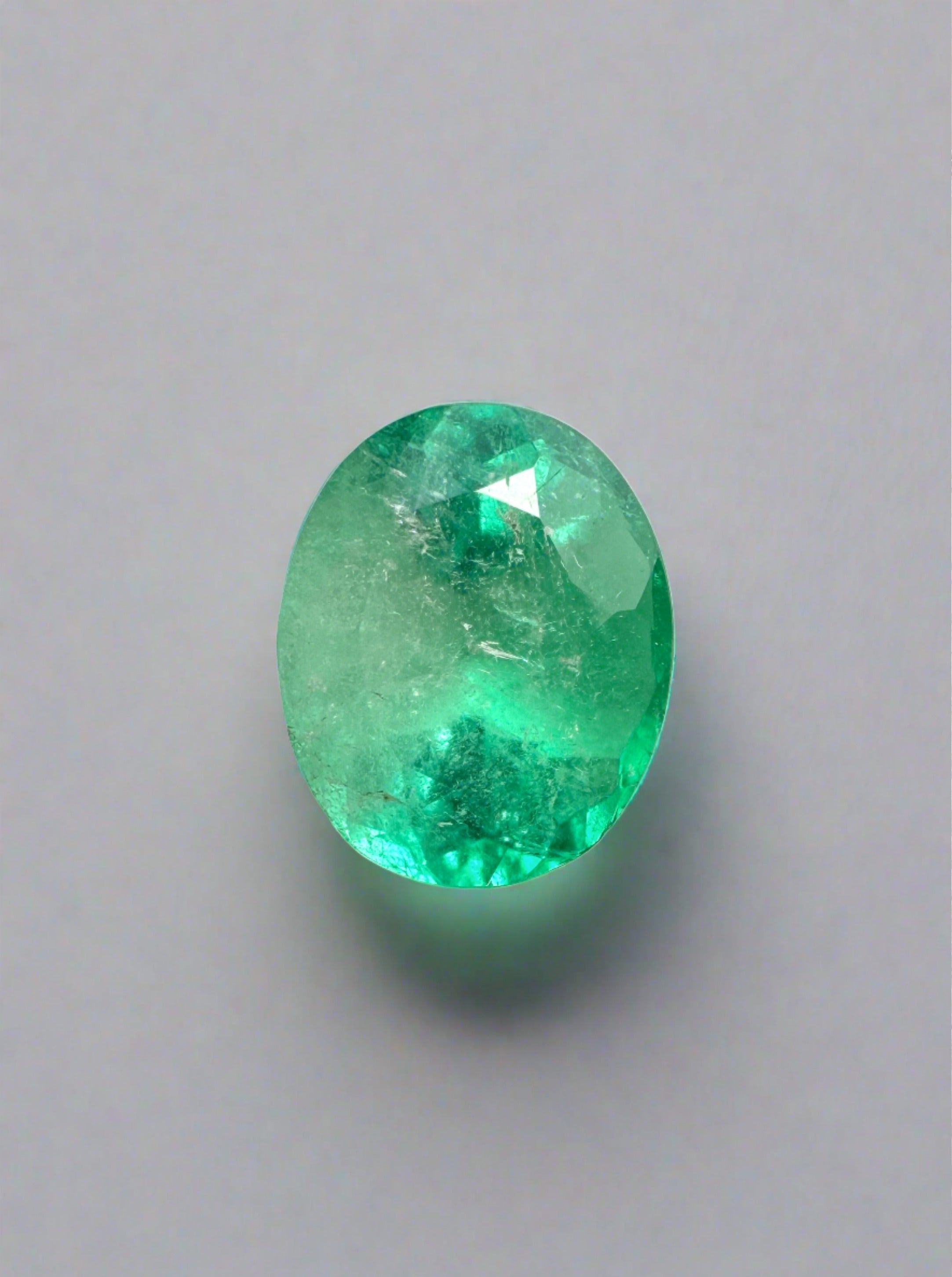 Light spring green 1.55 carat oval cut natural Colombian emerald by JR Colombian Emeralds on a neutral background.