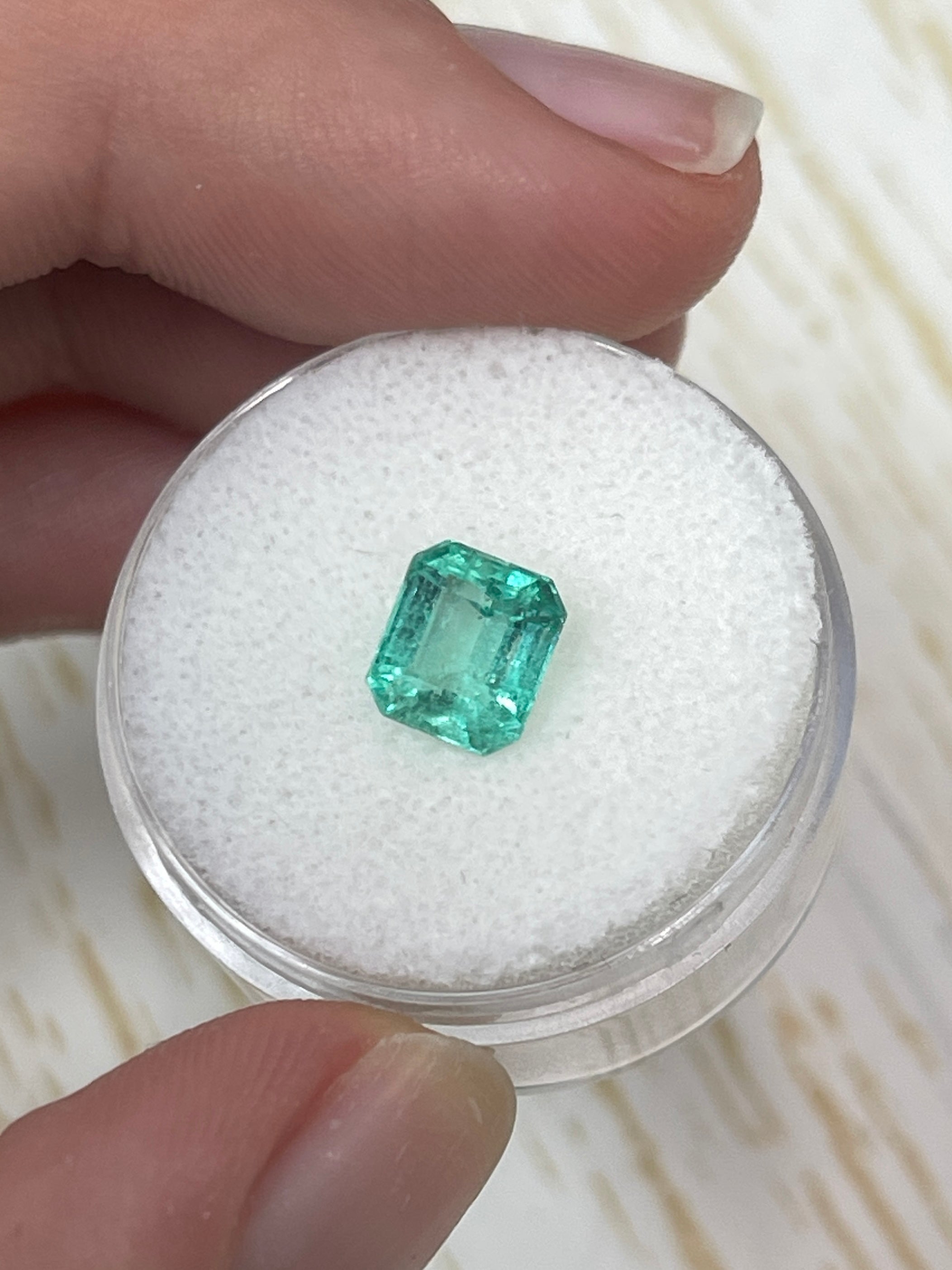 1.59 carat pastel green natural Colombian emerald loose gemstone in emerald cut, showcasing its vibrant color and clarity.