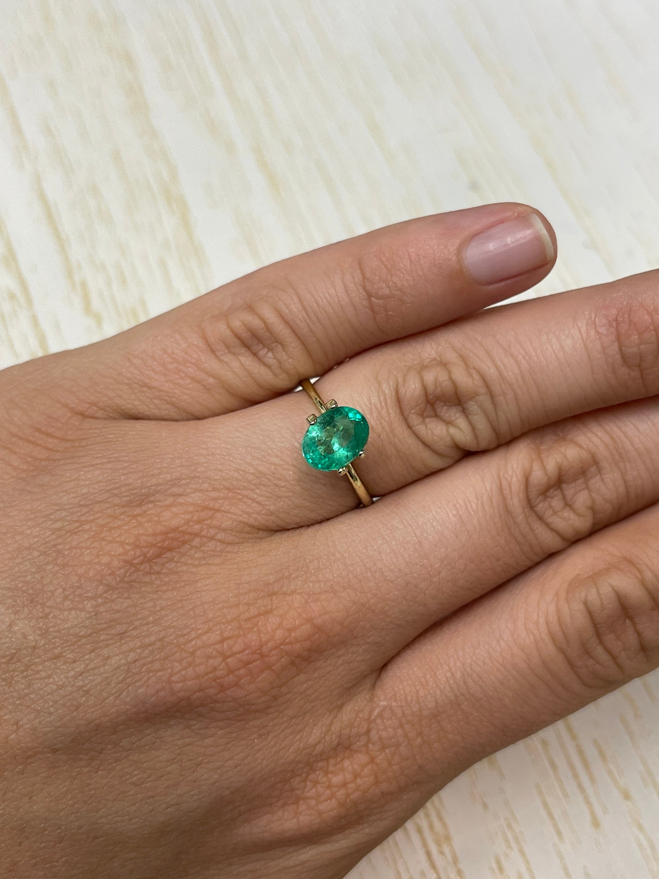 Loose 1.64 carat oval cut Colombian emerald from JR Colombian Emeralds, vibrant green natural gemstone on a white background.