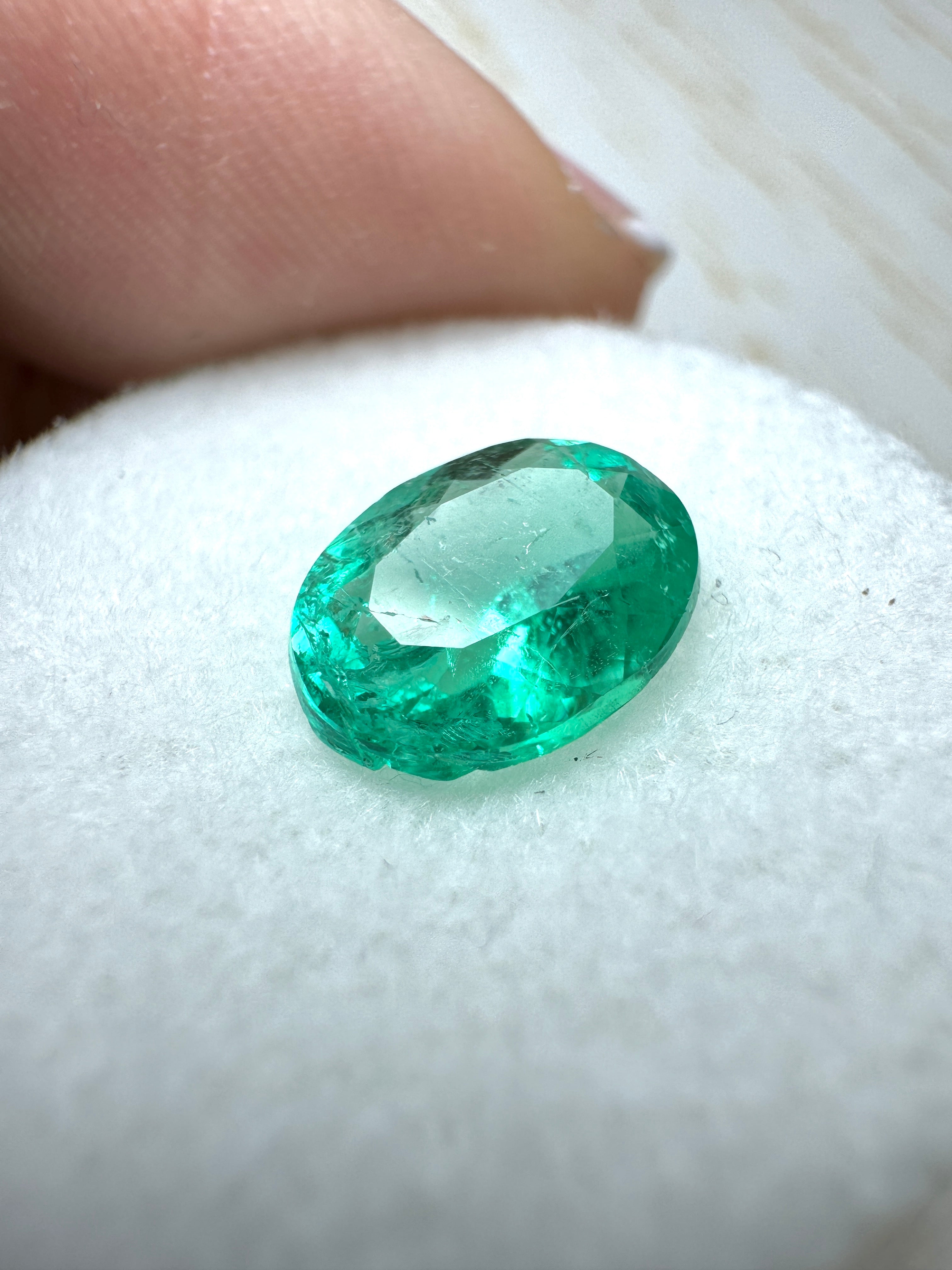 Natural 1.64 carat oval cut Colombian emerald from JR Colombian Emeralds, showcasing vibrant green color and smooth surface.