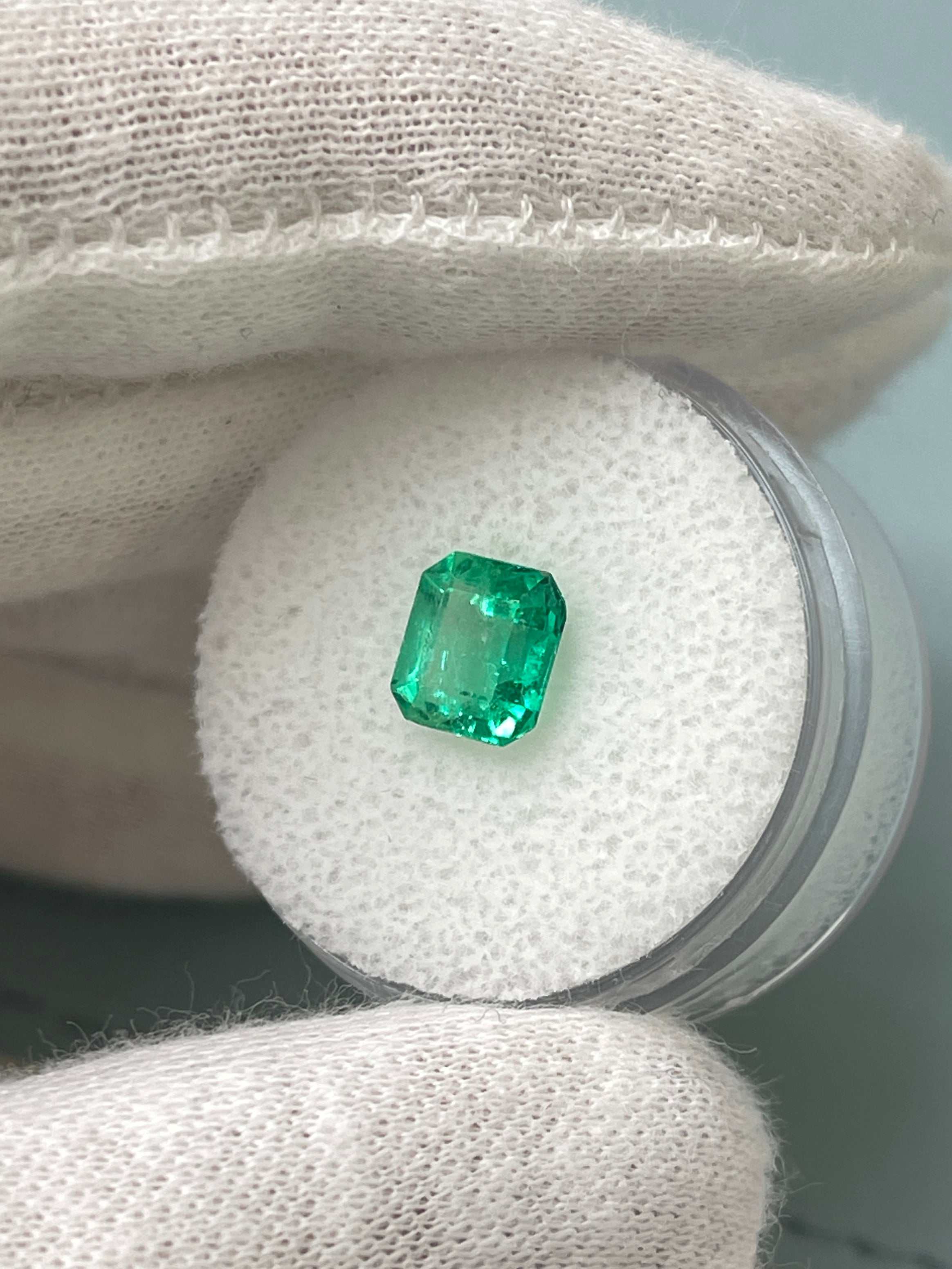 1.68 carat yellowish green Asscher cut natural Colombian emerald from JR Colombian Emeralds with crystalline facets.