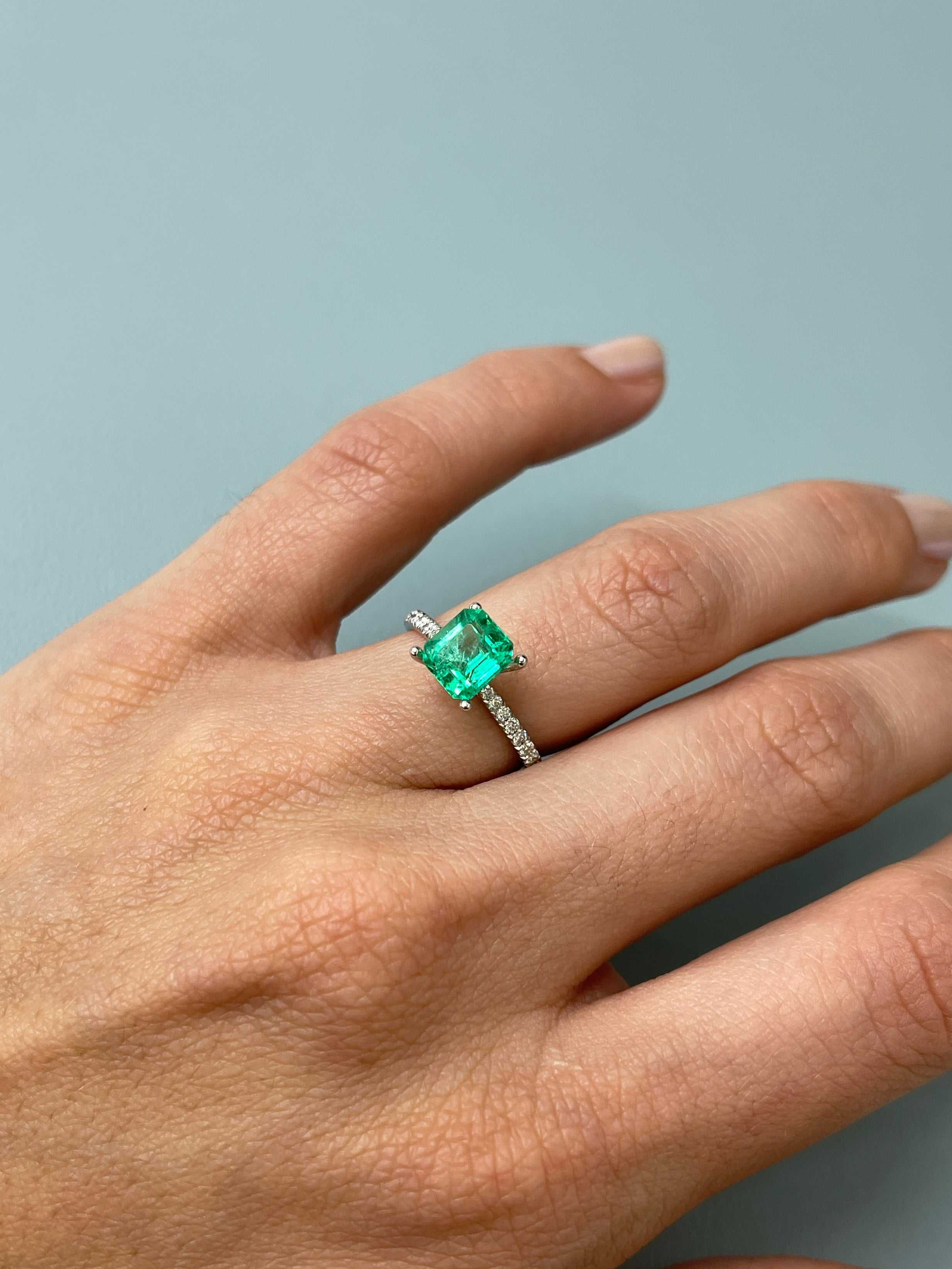 1.68 carat yellowish green Asscher cut natural Colombian emerald with crystalline texture against a neutral background.