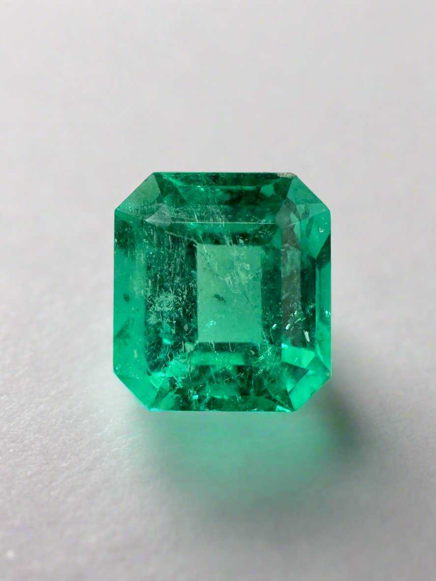 1.68 carat yellowish green Colombian emerald, 7.5x7 Asscher cut, showcasing crystalline clarity and natural beauty.