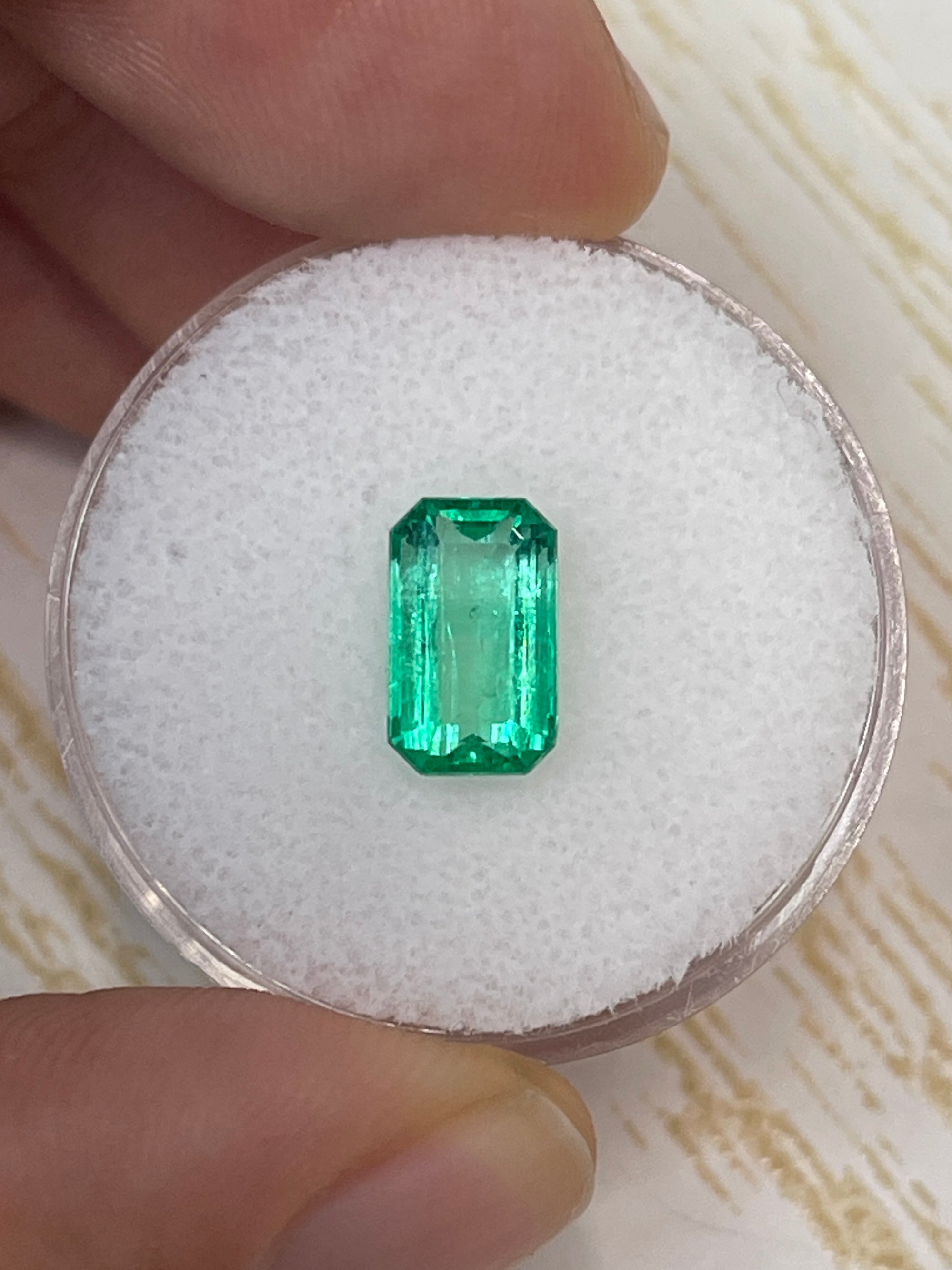 Natural 1.68 carat yellowish green Colombian emerald loose gemstone in emerald cut, showcasing clarity and vibrant color.