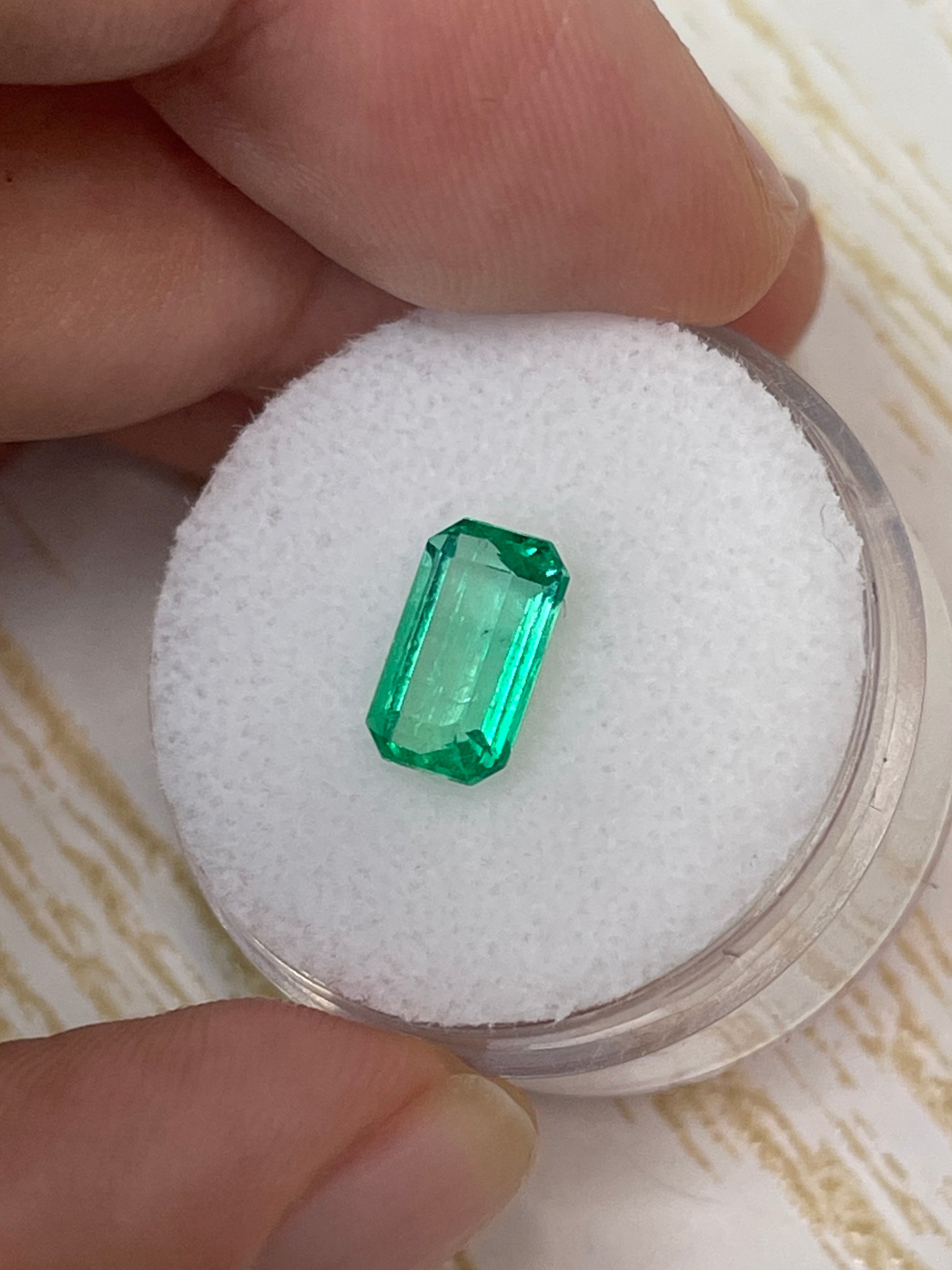 Yellowish green 1.68 carat natural Colombian emerald in an emerald cut, displayed as a loose gemstone.