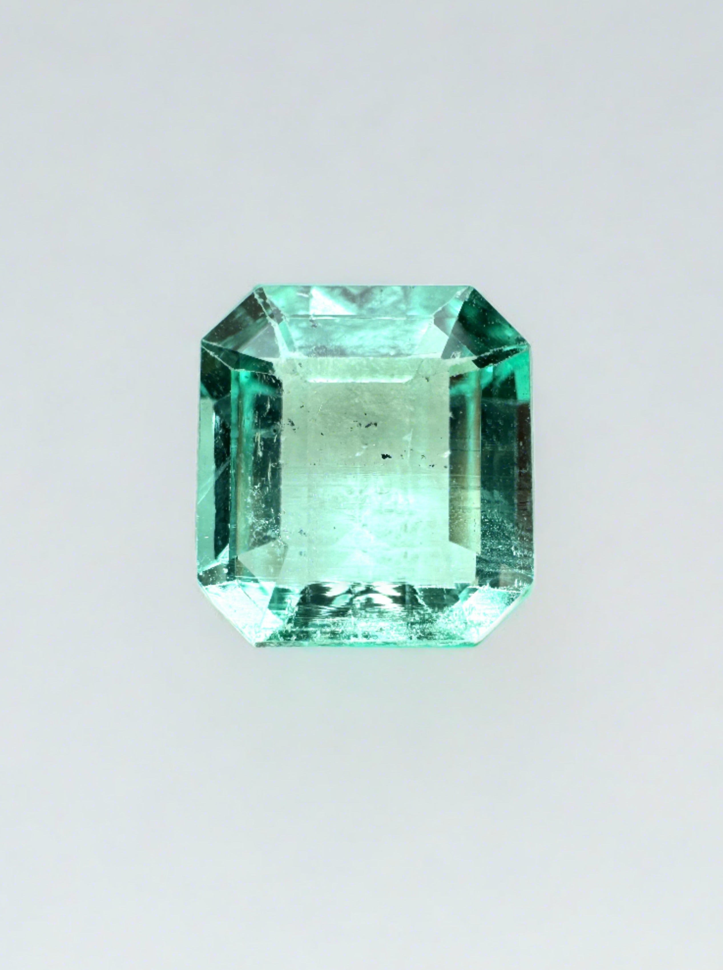 1.74 carat freckled Colombian emerald in Asscher cut, loose gemstone showcasing vivid green color and unique natural inclusions.