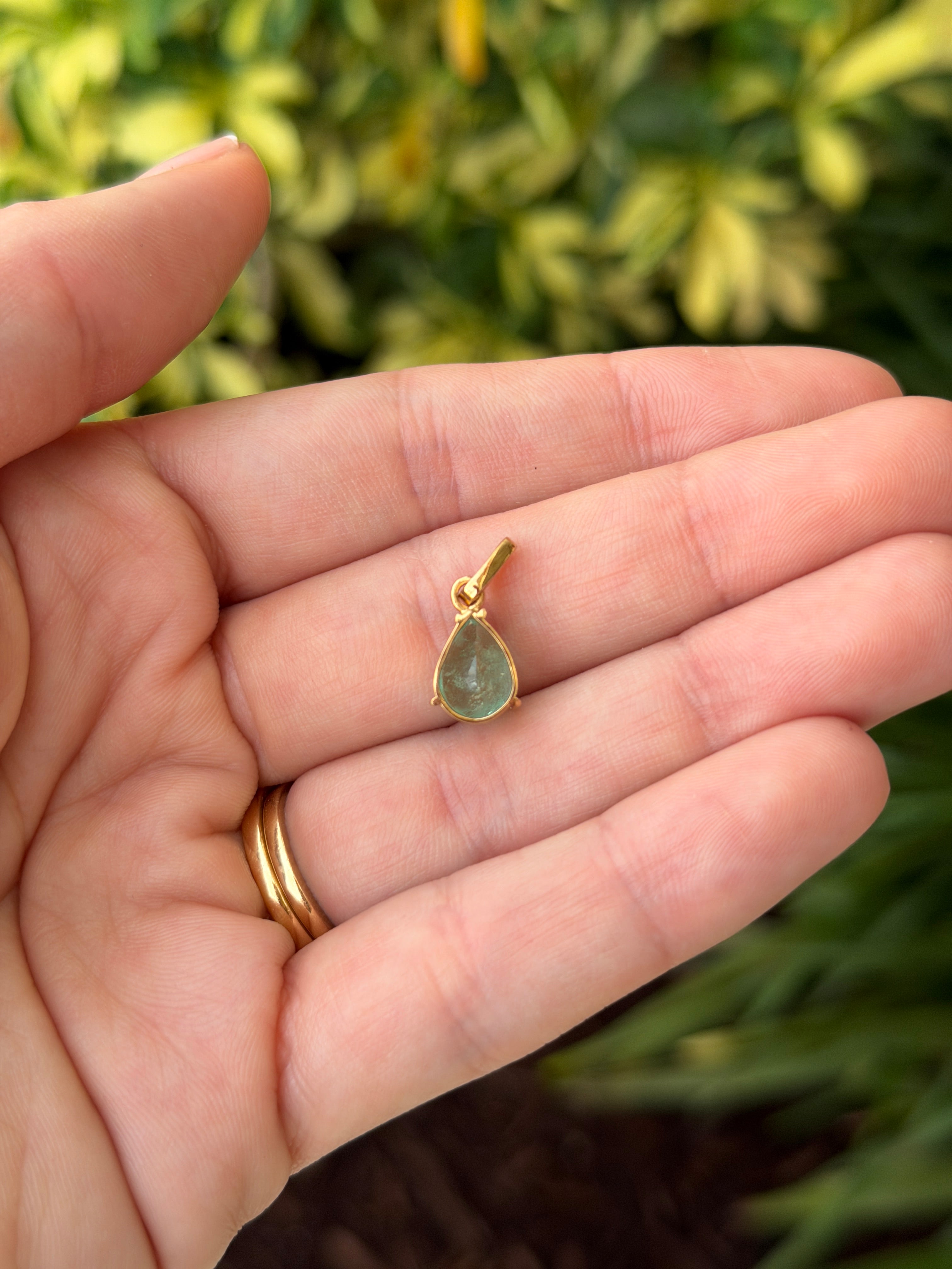 Light green Colombian emerald pear cut solitaire necklace featuring a 1.80 carat emerald pendant on a delicate chain.