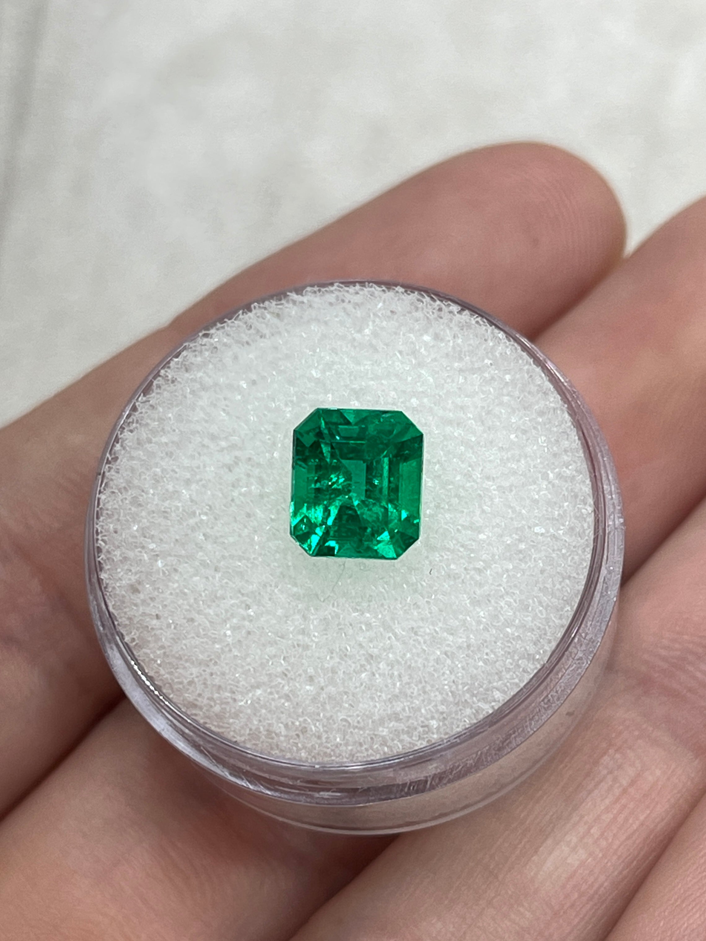 Vivid yellowish green 1.82 carat Colombian emerald loose gemstone in an emerald cut, displayed by JR Colombian Emeralds