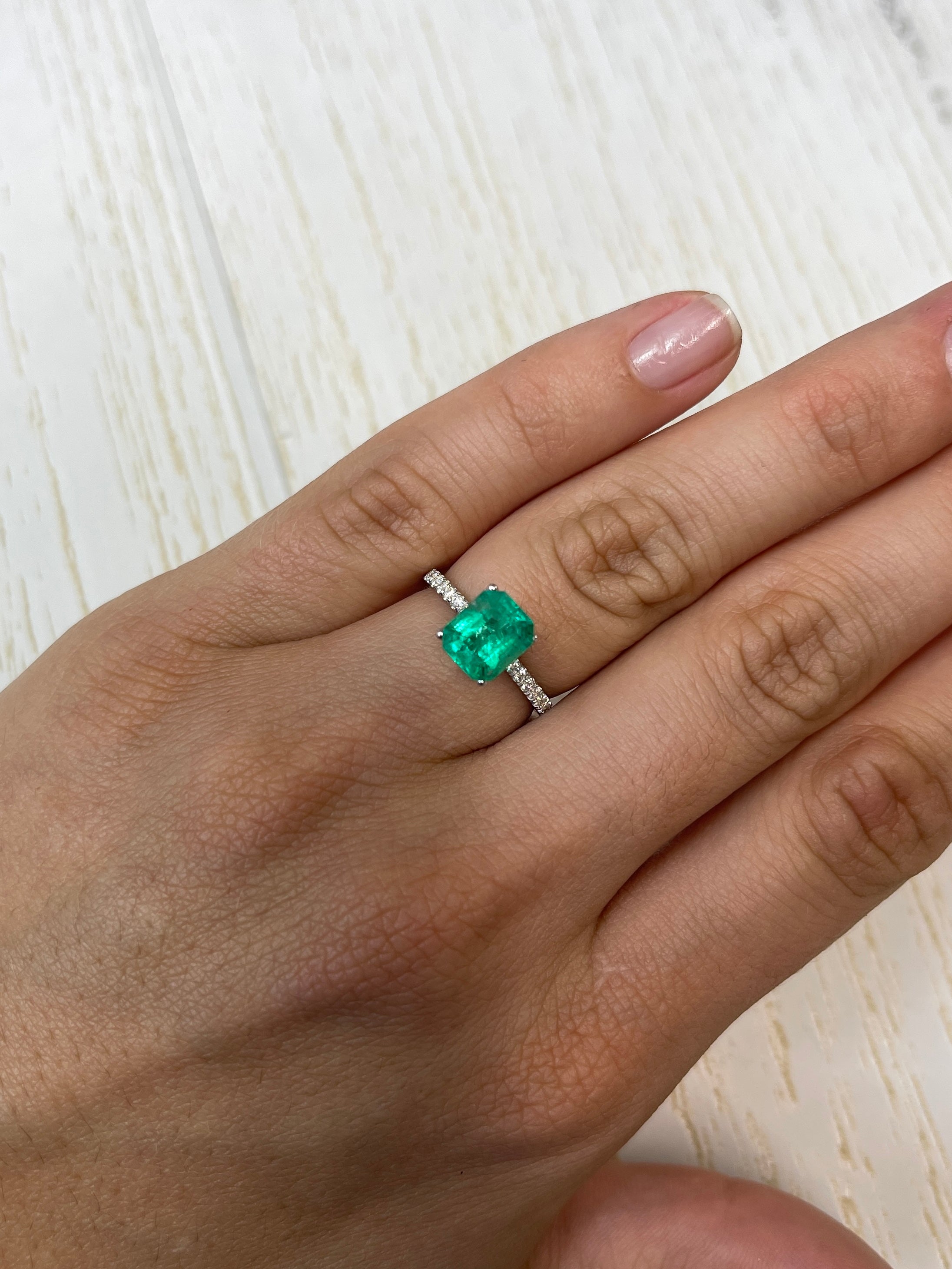 Freckled green 1.94 carat Colombian emerald loose gemstone in an emerald cut, shown from JR Colombian Emeralds.