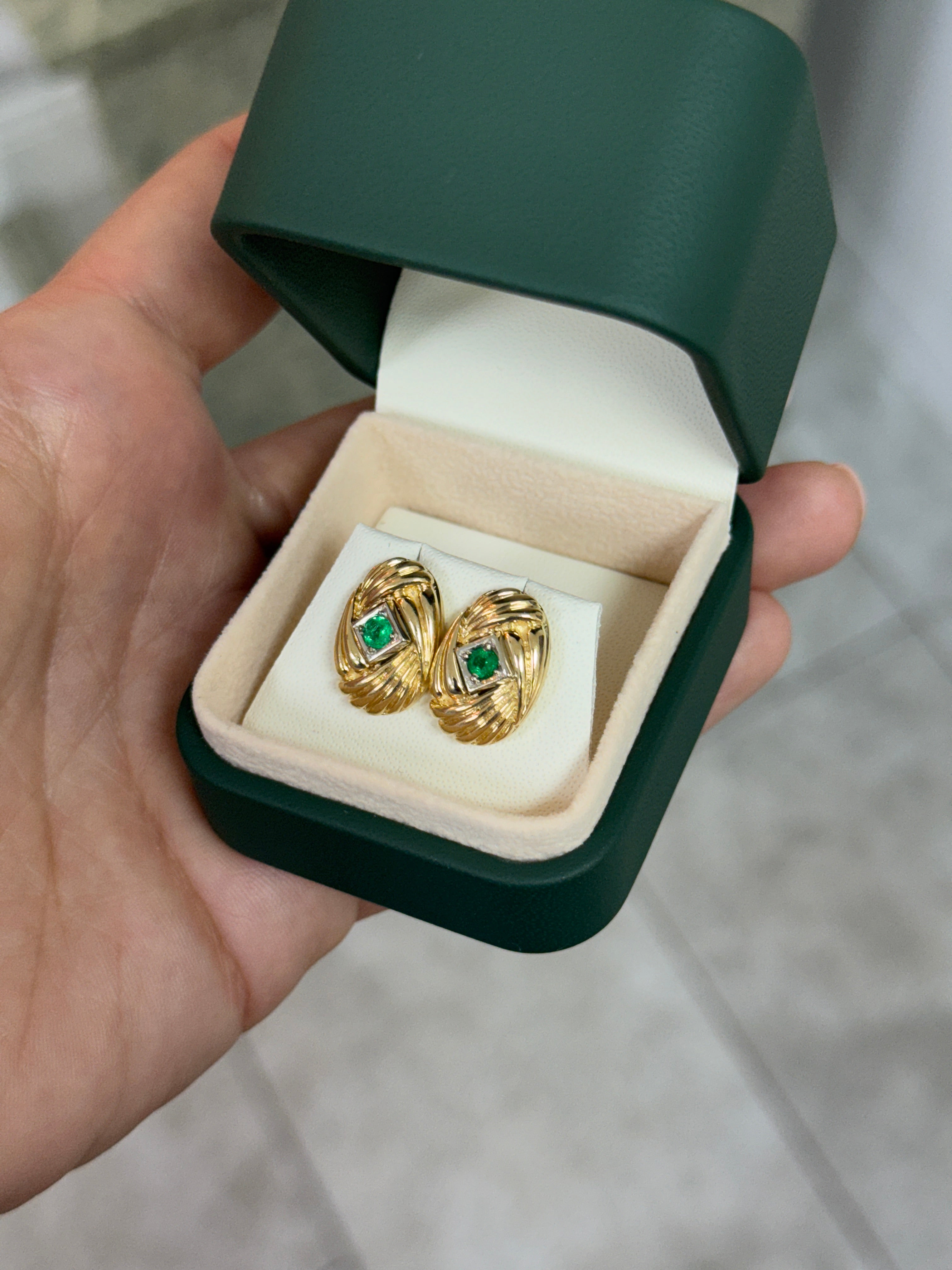 14K gold vintage Zambian emerald statement earrings with scroll and vortex design, featuring 0.70tcw of vibrant green emeralds.