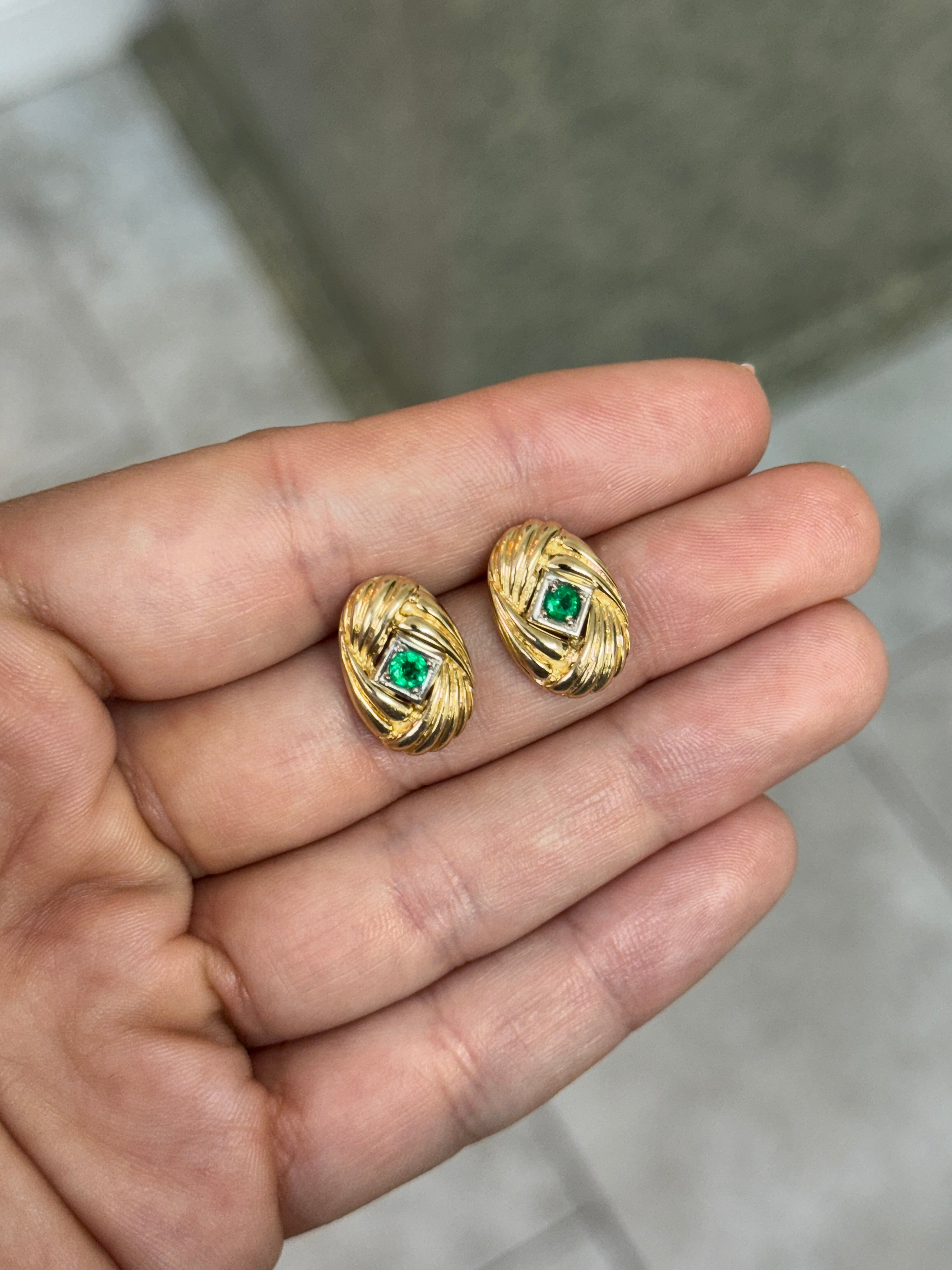 14K gold vintage Zambian emerald statement earrings with scroll and vortex design, featuring 0.70tcw of vibrant green emeralds.