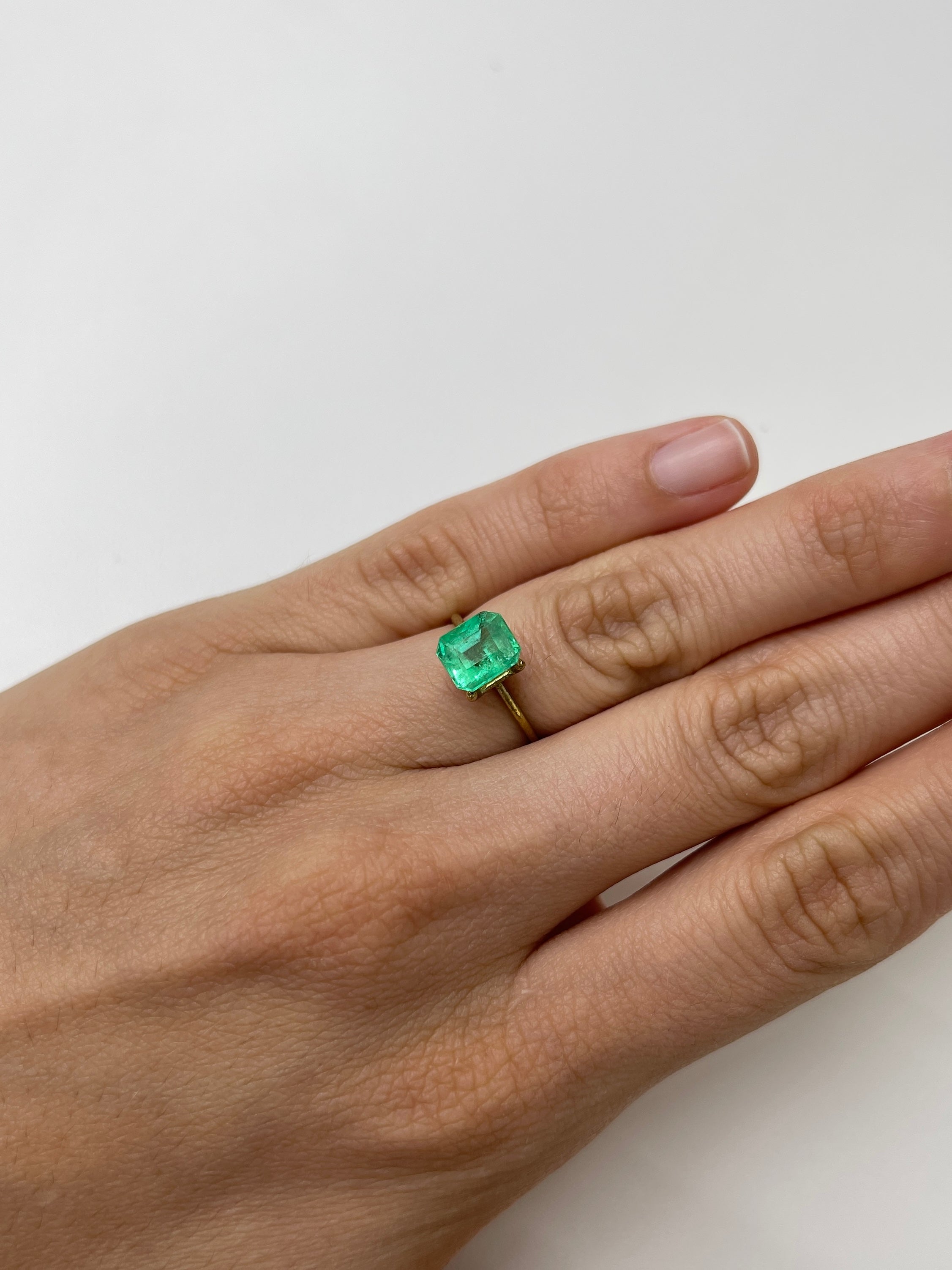 2.08 Carat lime yellowish emerald cut natural Colombian emerald gemstone, unset and showcasing vibrant color and clarity.