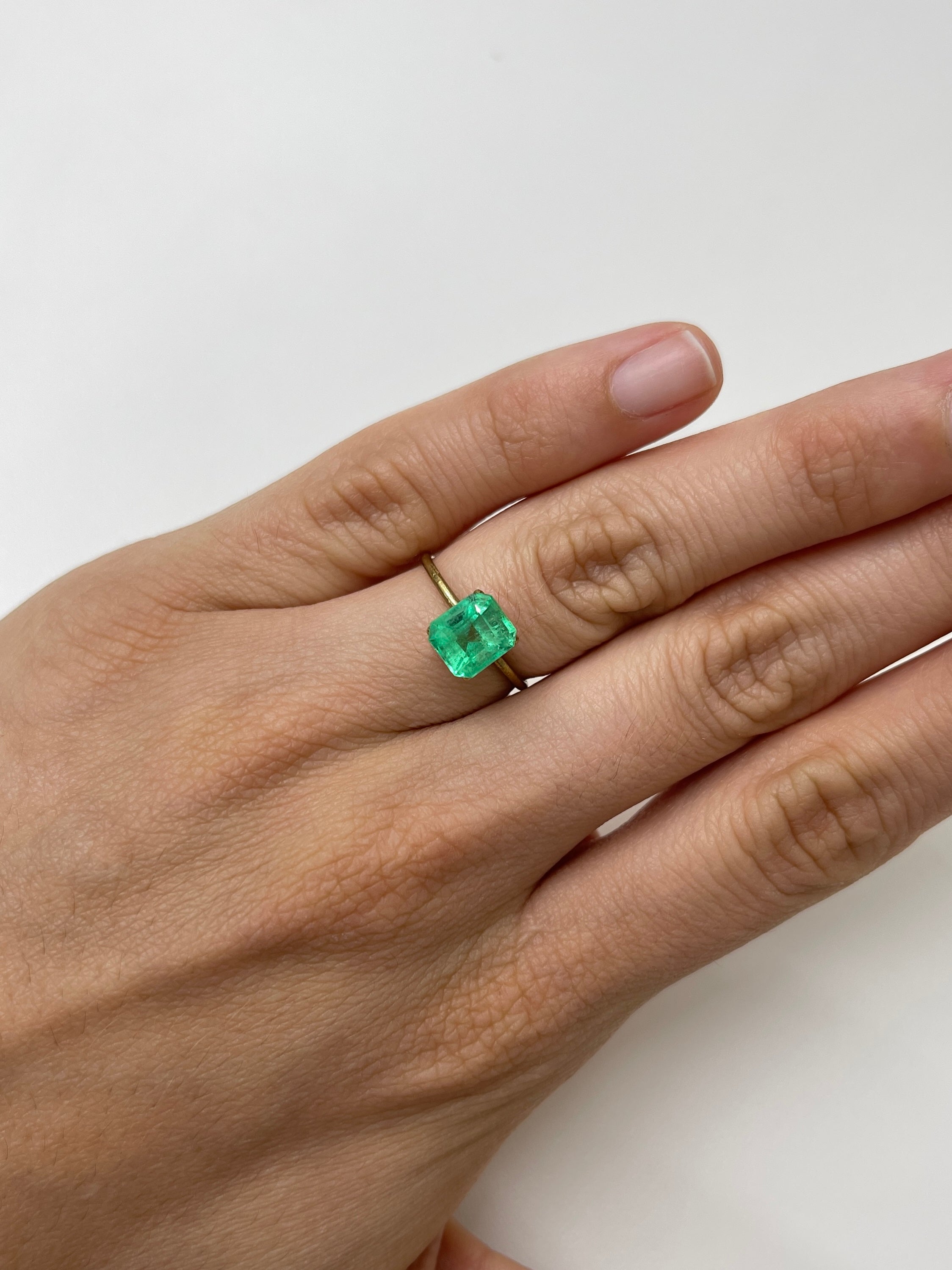 2.08 carat lime yellowish emerald cut Colombian emerald from JR Colombian Emeralds, natural and unset, showcasing vibrant color and clarity.