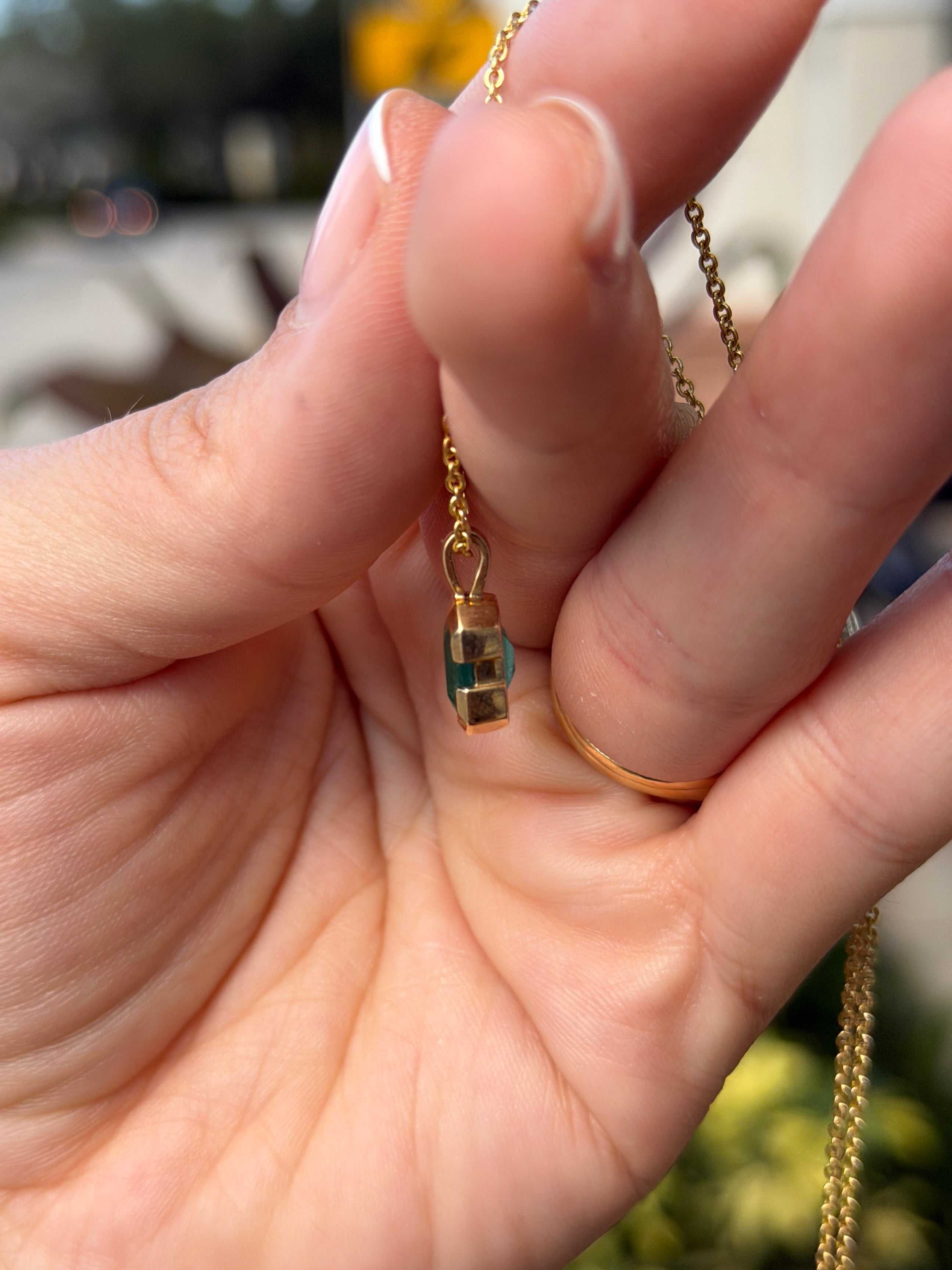 14K gold emerald solitaire necklace featuring a 2.28 carat semi-bezel emerald by JR Colombian Emeralds, touches skin with elegant design.