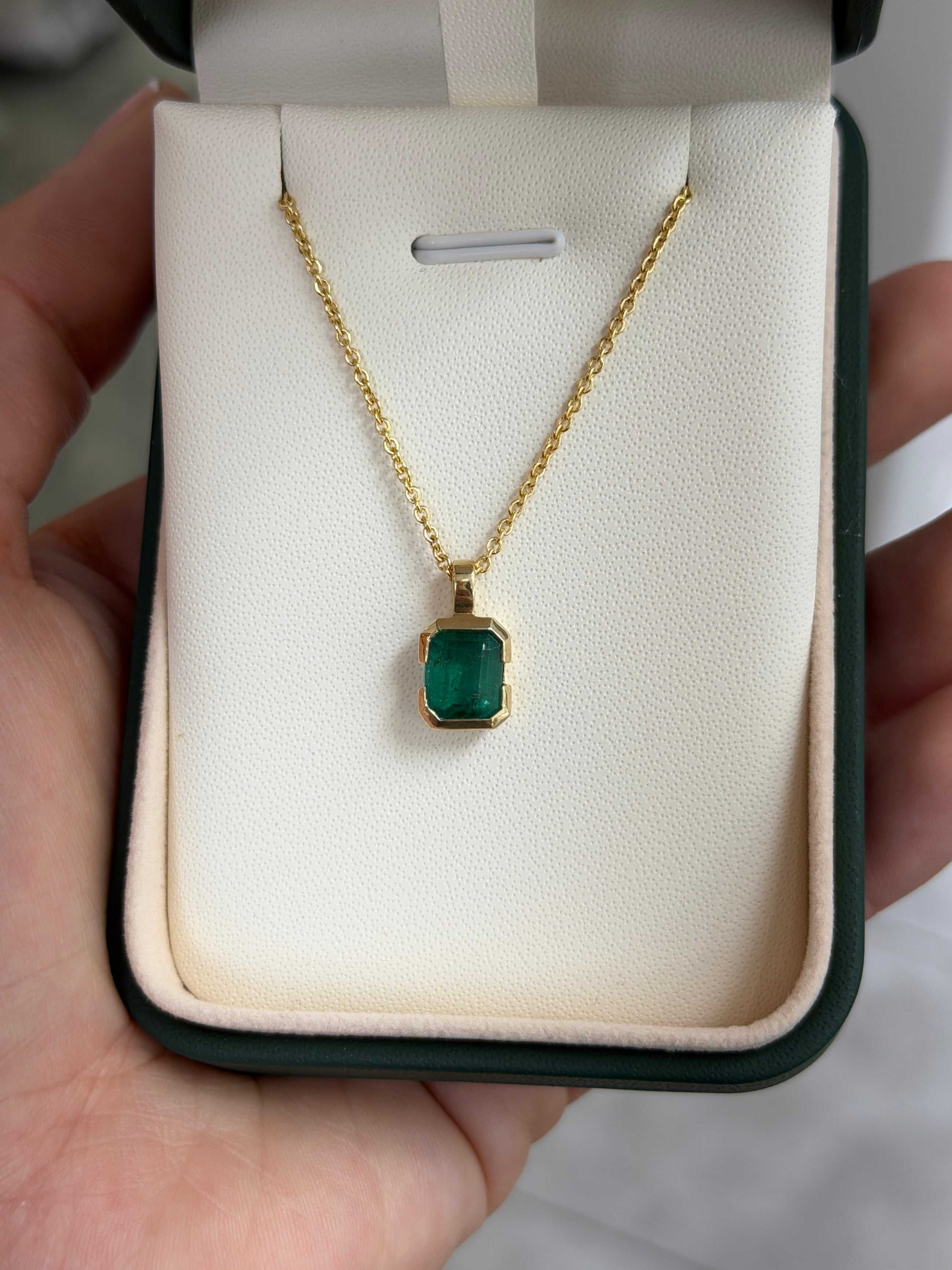 14K gold semi-bezel emerald solitaire necklace featuring a 2.28 carat emerald by JR Colombian Emeralds, touches the skin with elegance.