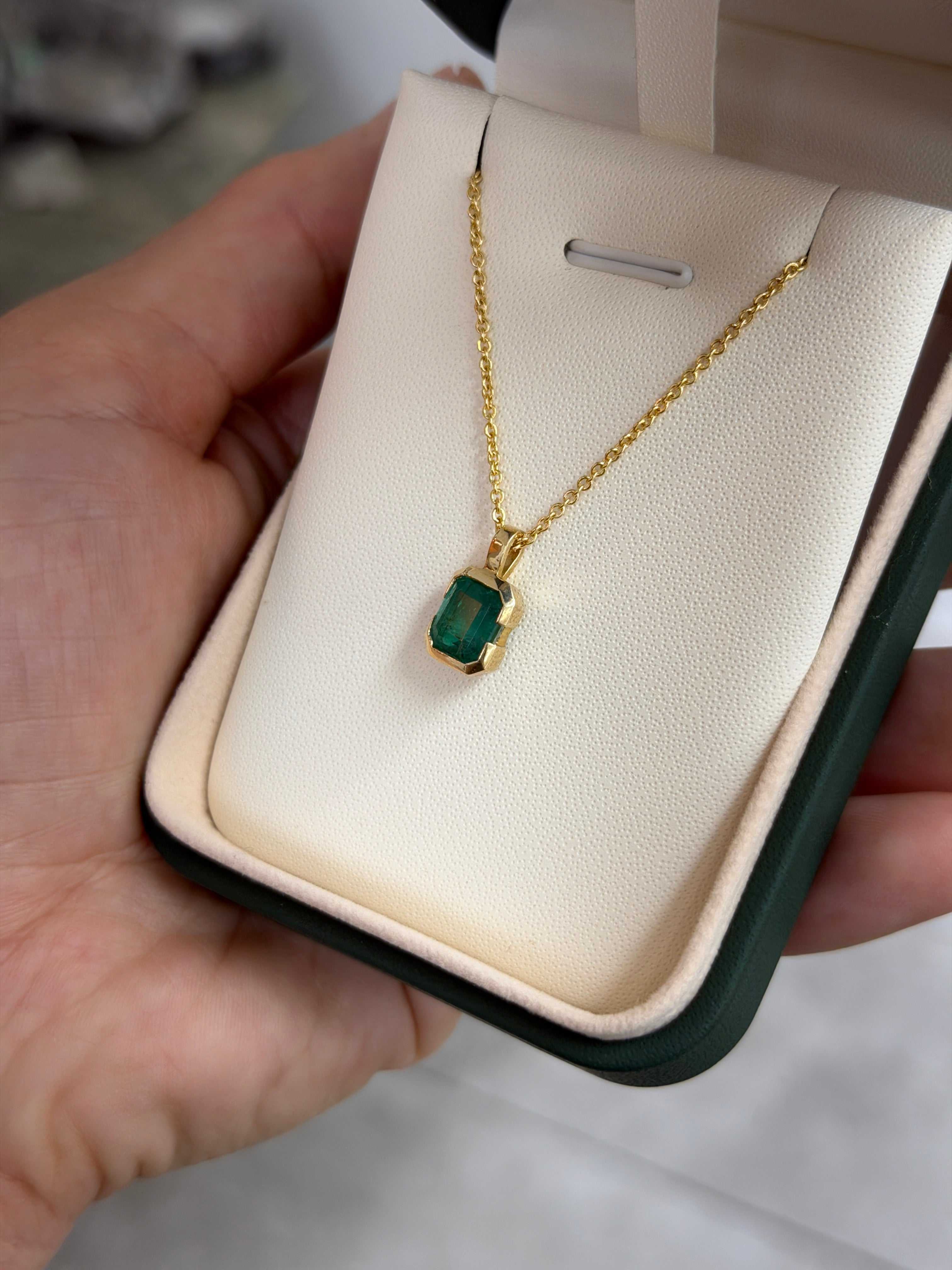 14K gold emerald solitaire necklace featuring a 2.28 carat semi-bezel emerald pendant touching the skin, by JR Colombian Emeralds.