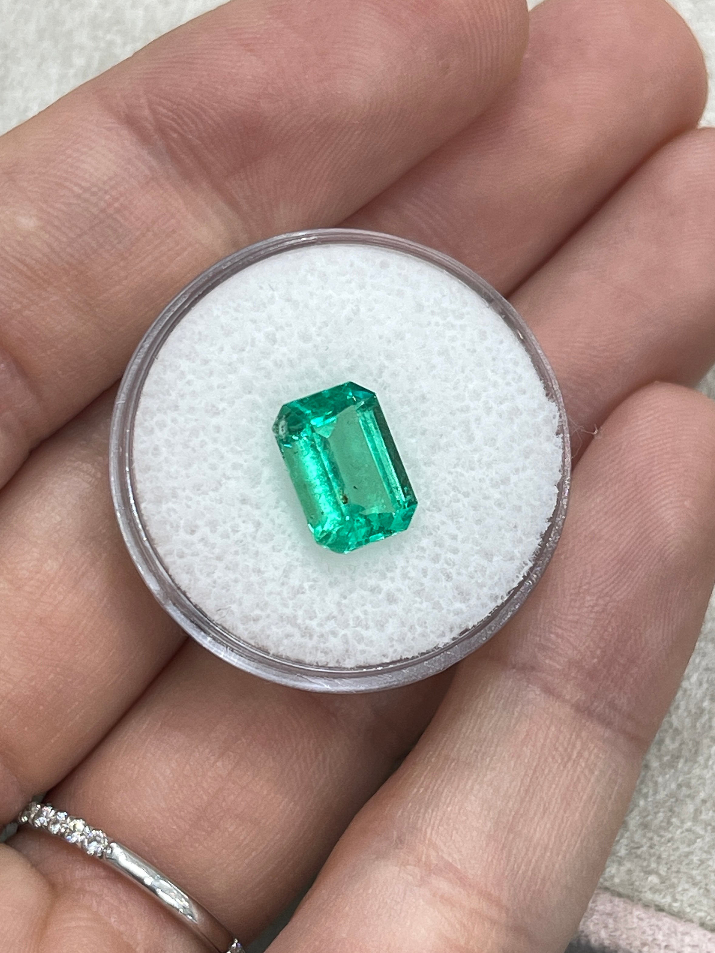 2.31 carat medium green Colombian emerald cut emerald with natural freckles, displayed from JR Colombian Emeralds.
