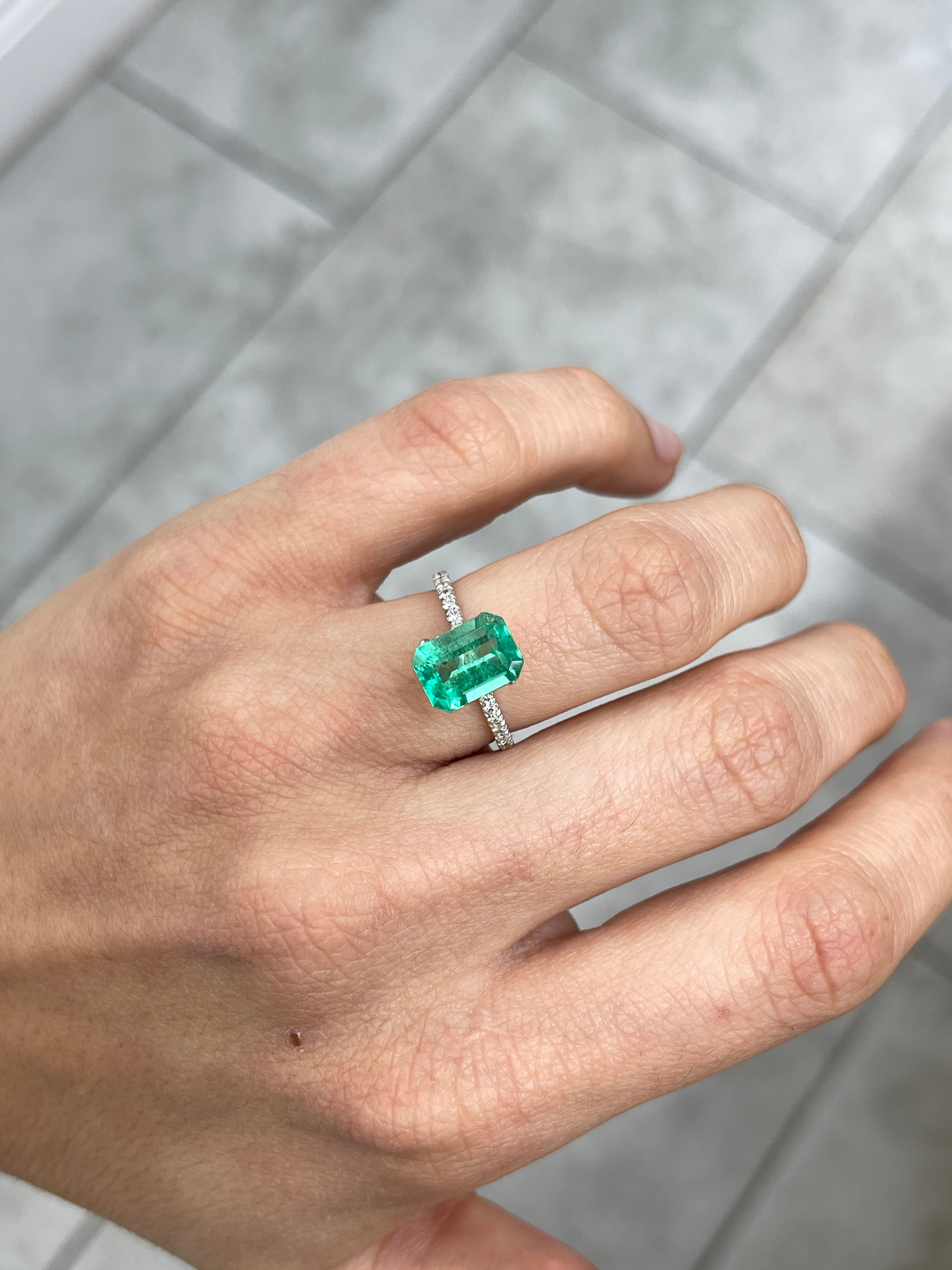 Freckled 2.31 Carat medium green Colombian emerald cut gemstone from JR Colombian Emeralds, showcasing vibrant color and natural inclusions.