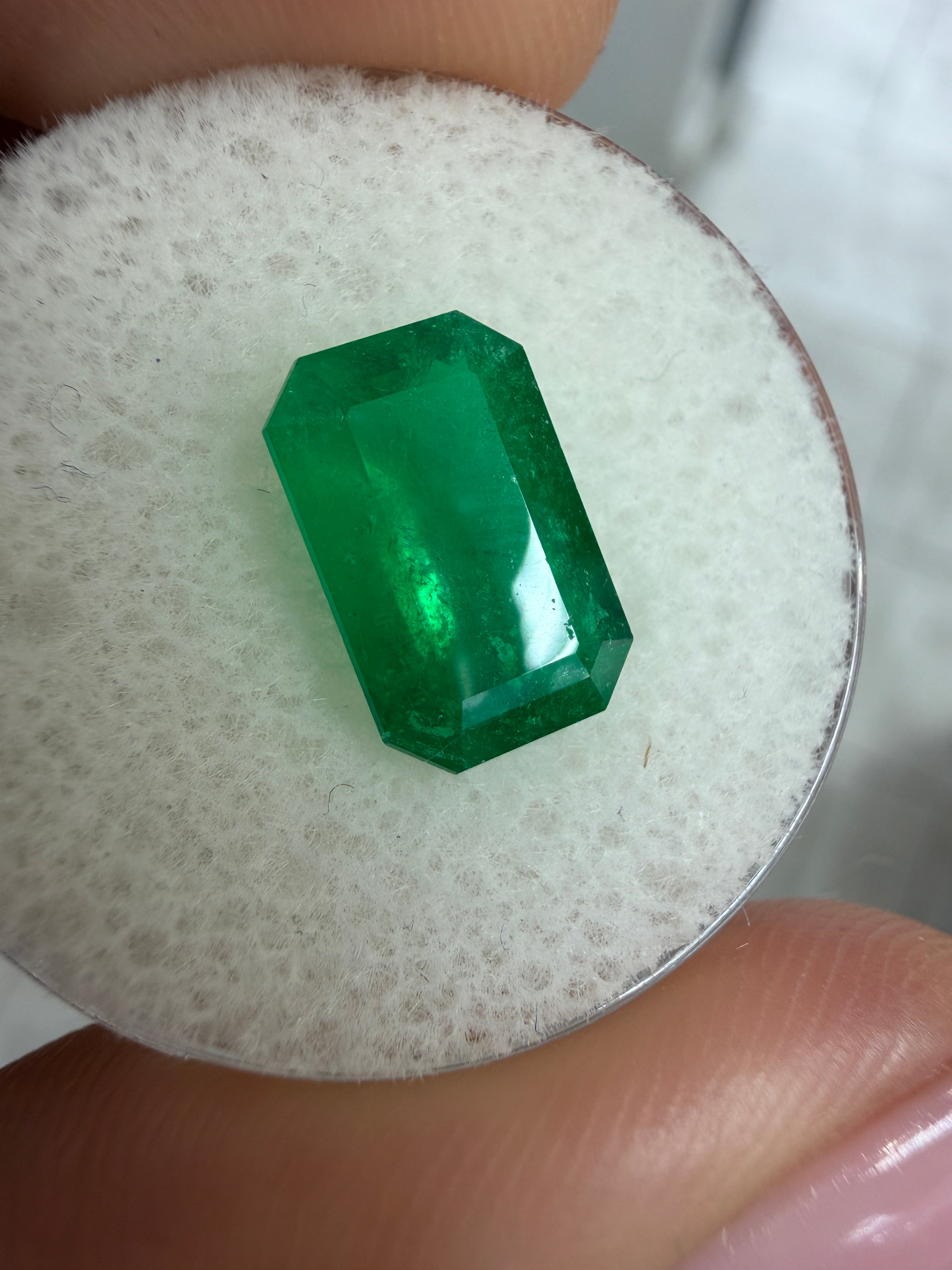 Deep jungle green 2.40 carat natural Colombian emerald in elongated emerald cut, displayed as a loose gemstone.