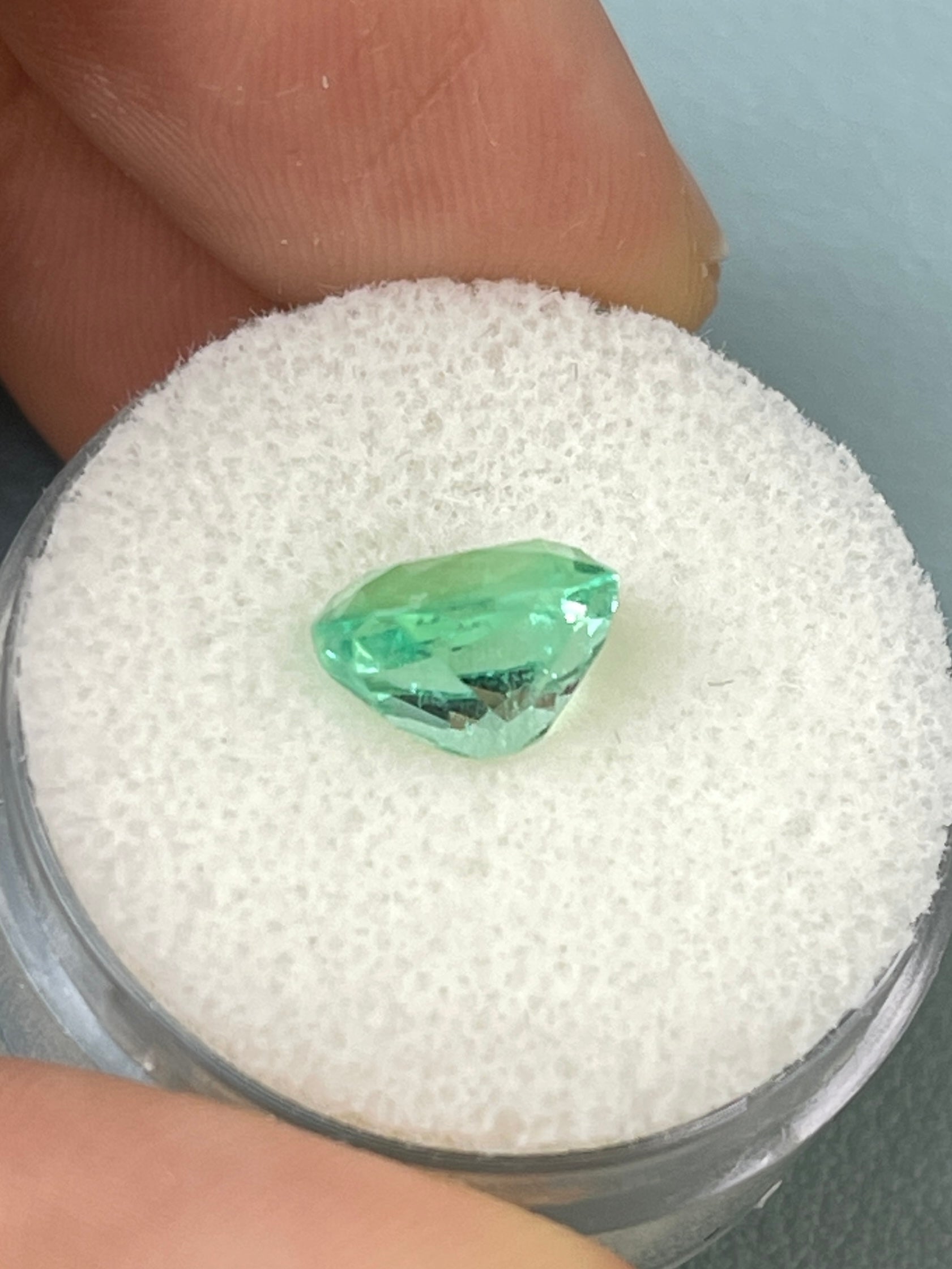 2.41 carat eye-clean green Colombian emerald loose cushion cut gemstone from JR Colombian Emeralds on a white background.