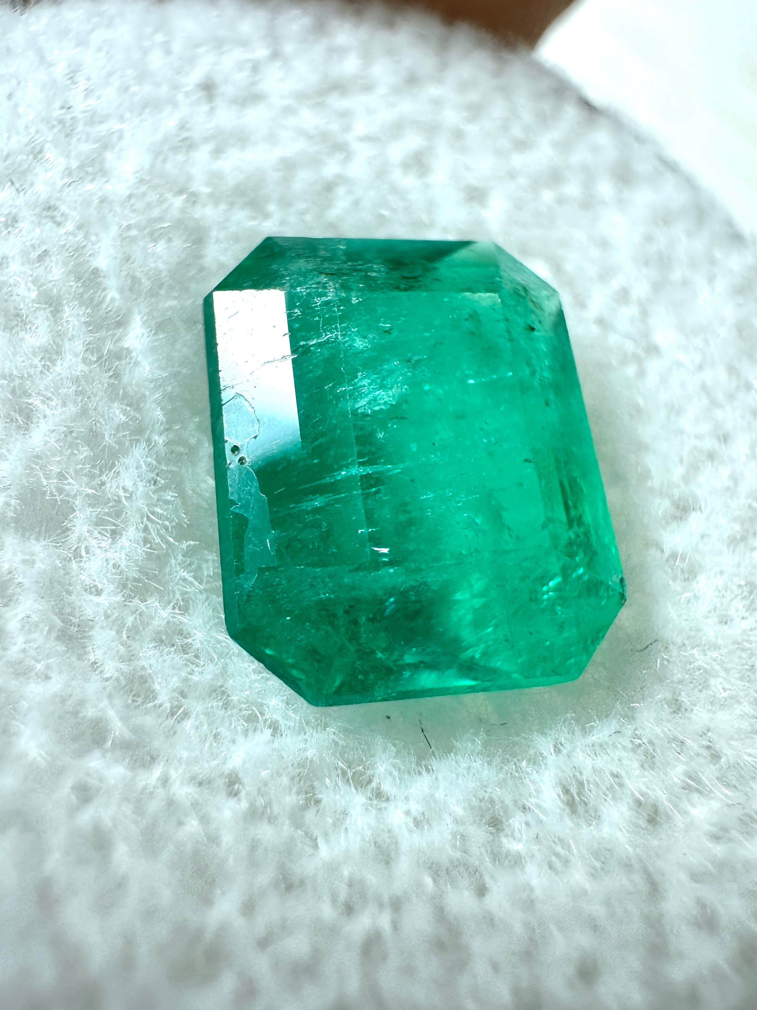 2.52 Carat intense green natural Colombian emerald loose gemstone in emerald cut, showcasing vibrant color and clarity.