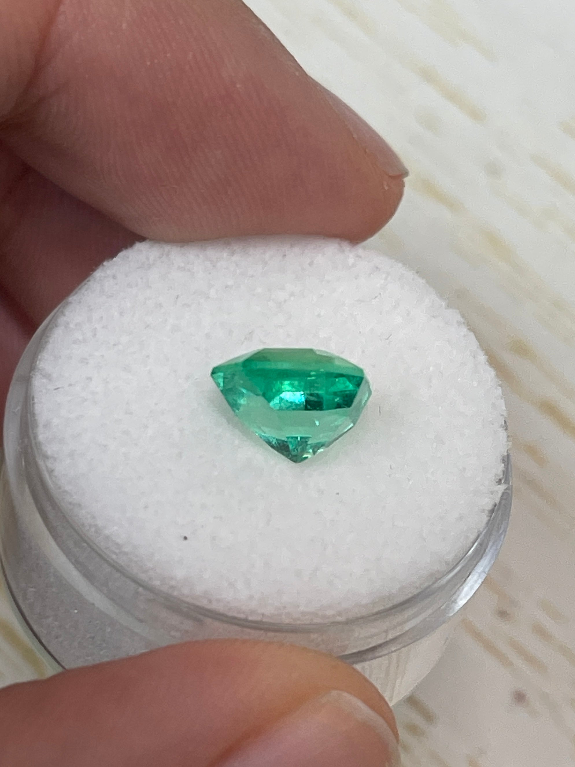 2.76 Carat vivacious natural Colombian emerald in Asscher cut with clipped corners, displayed as a loose gemstone by JR Colombian Emeralds.