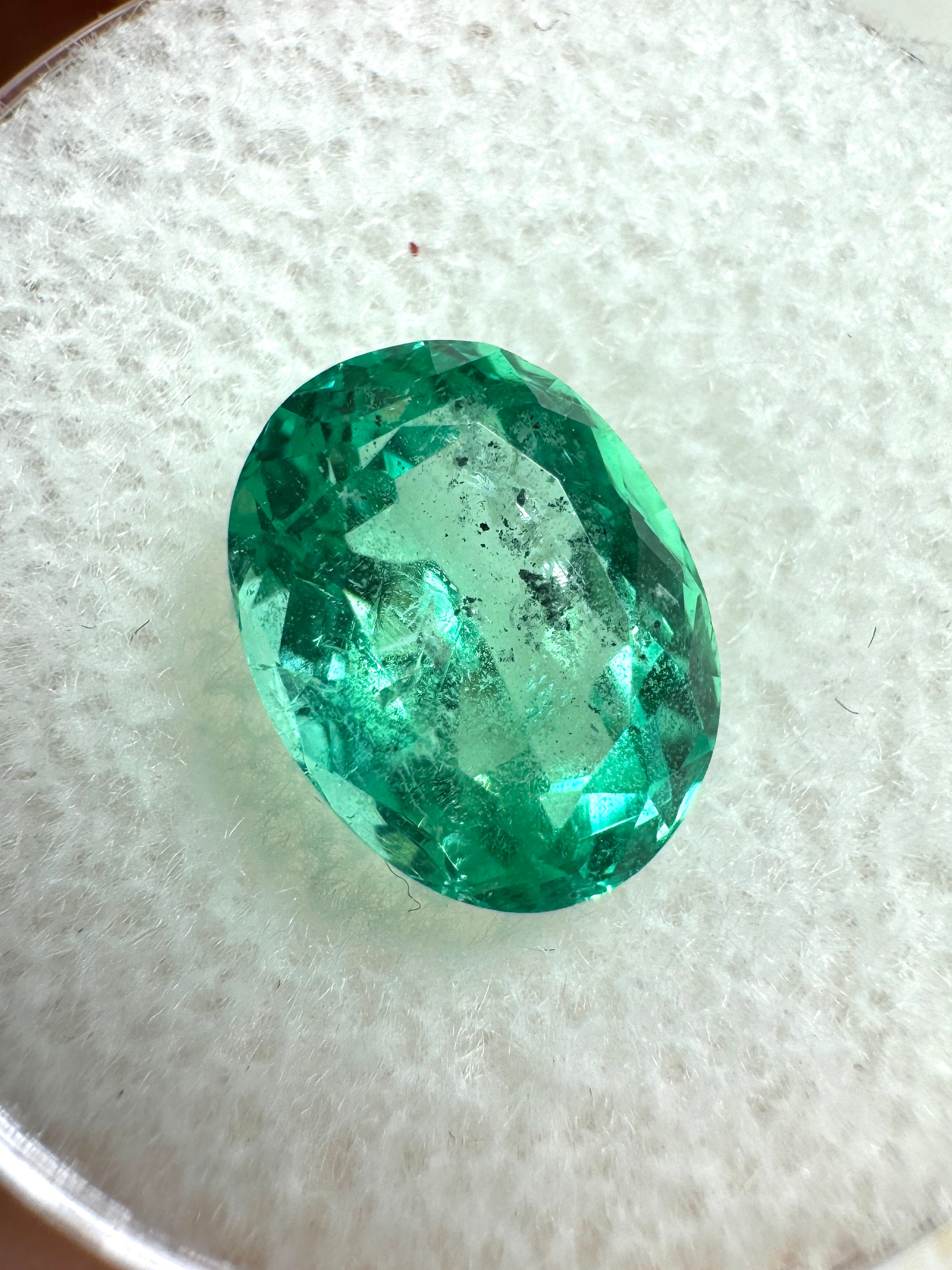 Vibrant 2.83 carat oval cut Colombian emerald with natural freckles, loose gemstone from JR Colombian Emeralds.