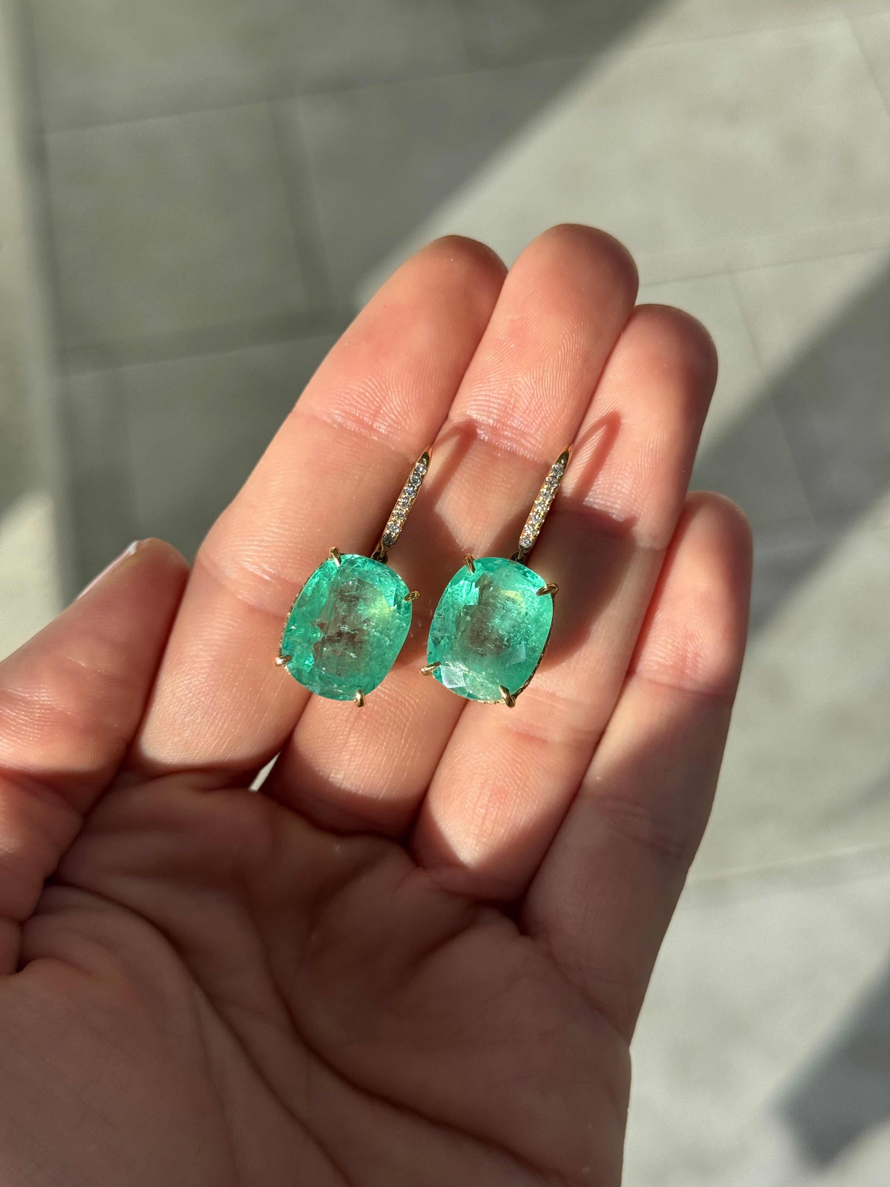 Large cushion cut Colombian emerald and diamond dangle earrings in 18K gold, featuring vibrant green emeralds and sparkling diamonds.