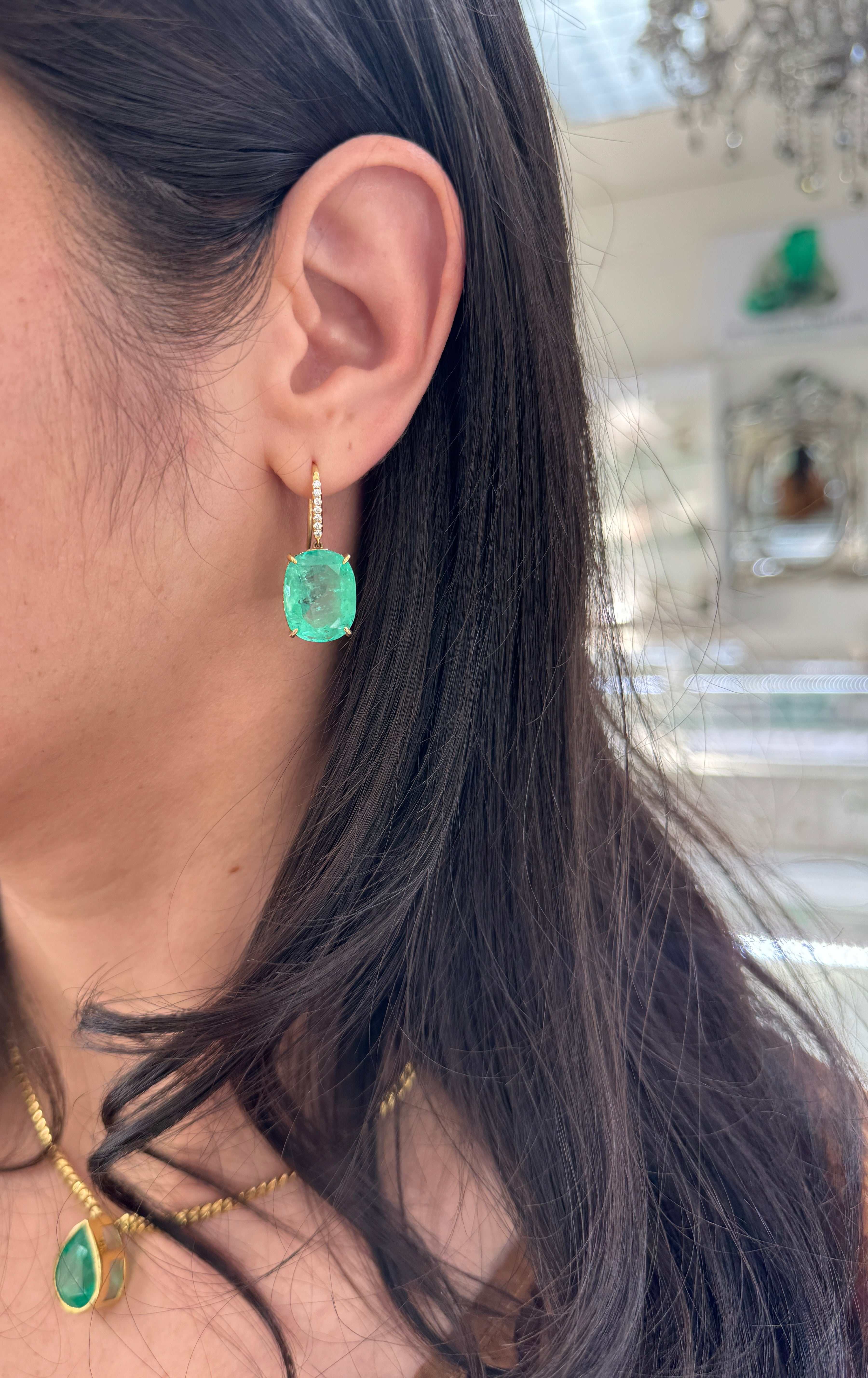 Large cushion cut Colombian emerald and diamond dangle earrings in 18K gold by JR Colombian Emeralds, showcasing vibrant gemstones.