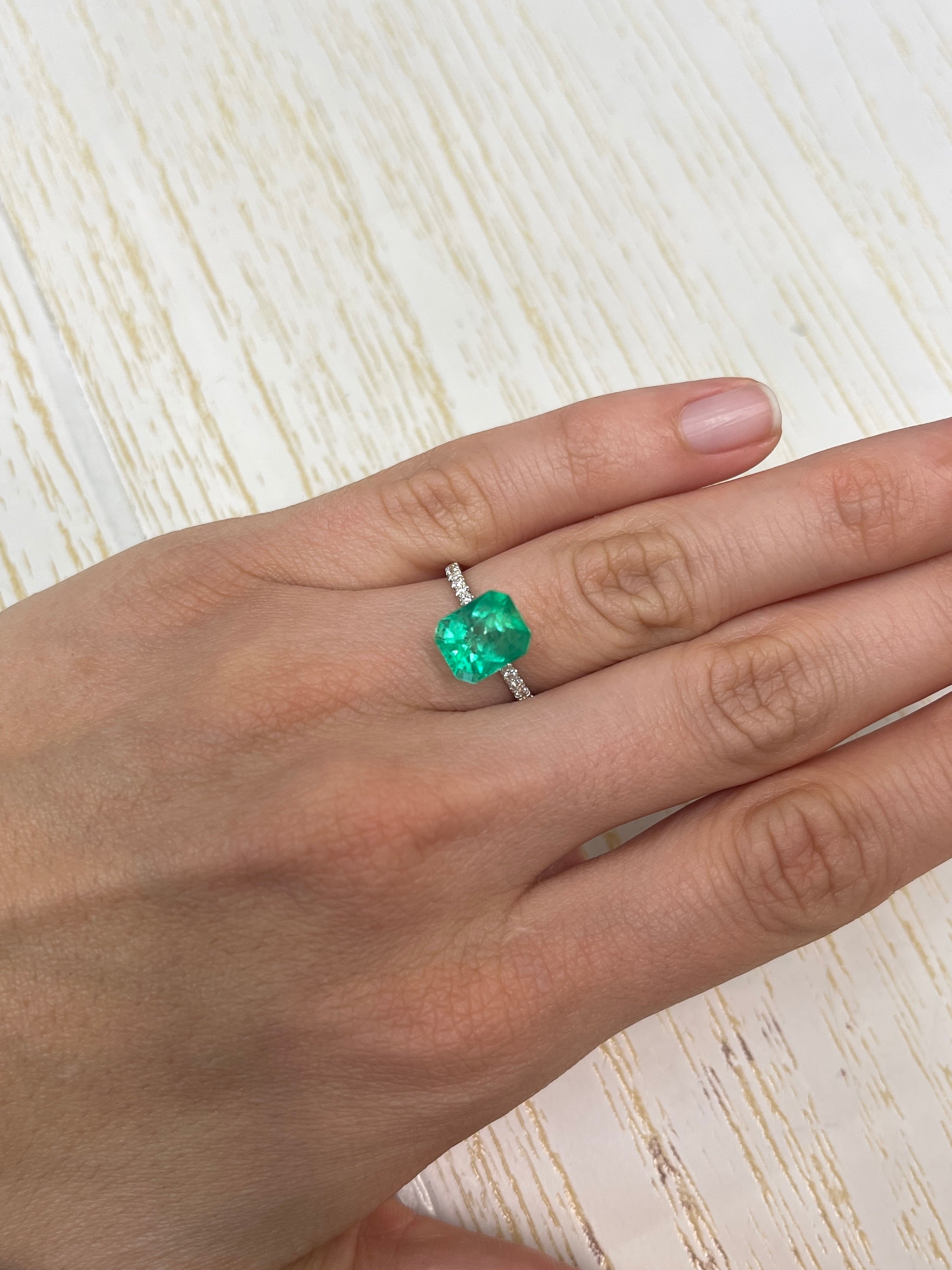 Electric yellowish 3.09 carat Colombian emerald in an emerald cut, featuring vibrant color and classic gemstone clarity.
