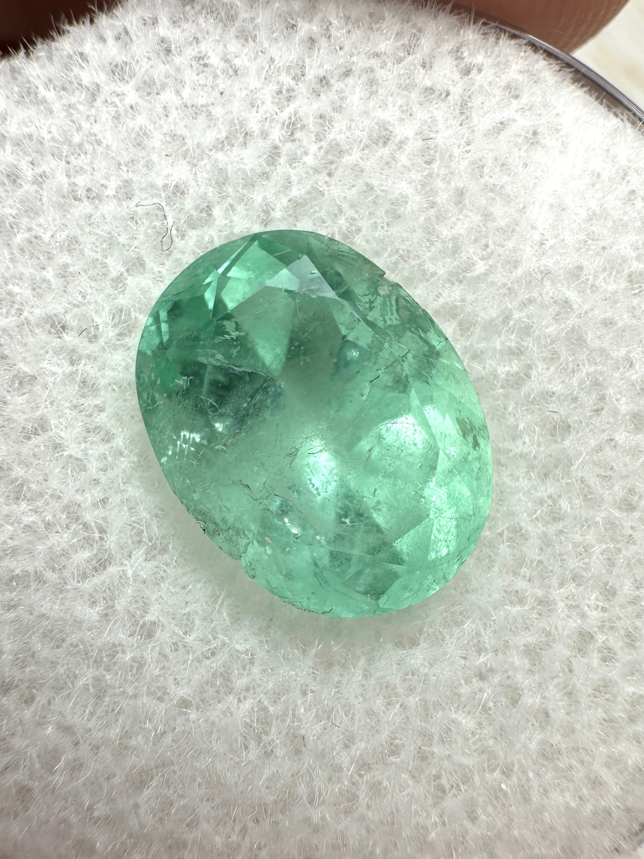 JR Colombian Emeralds 3.09 Carat pastel light green oval-cut Colombian emerald gemstone on a white background.