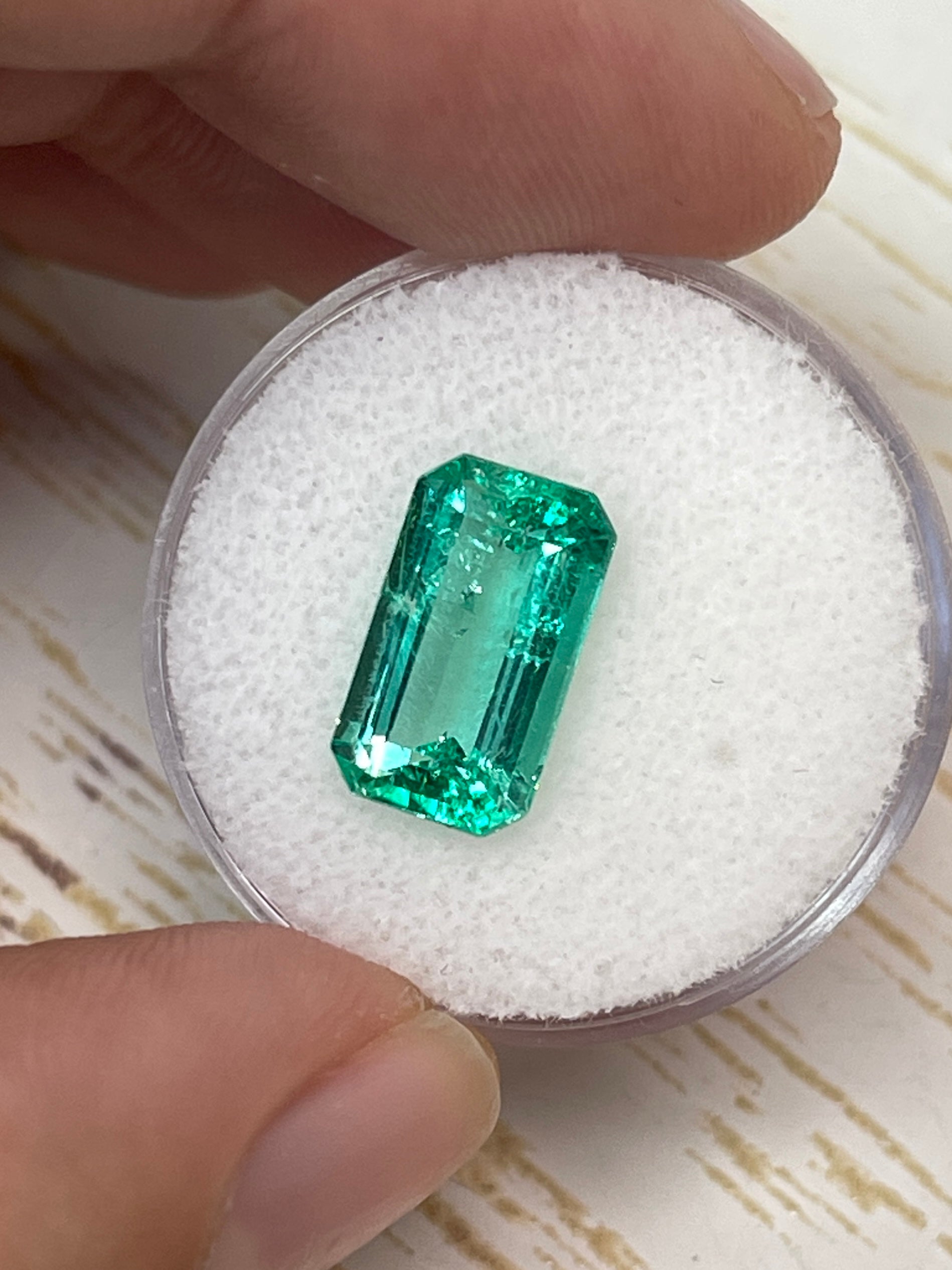 Elongated 3.42 carat natural Colombian emerald loose gemstone with emerald cut, vibrant green color, from JR Colombian Emeralds.