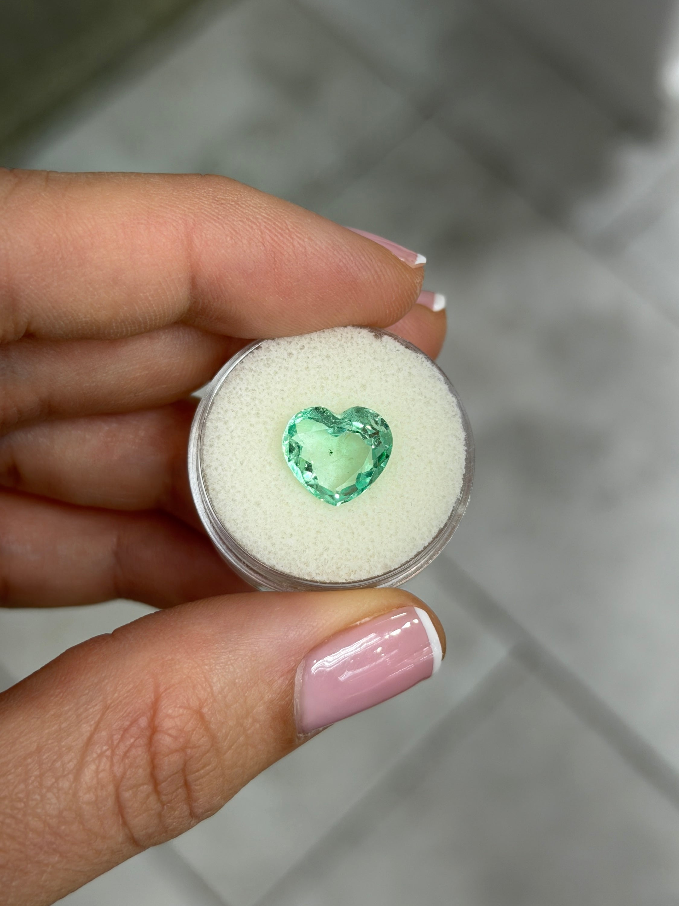 Light bluish green Colombian emerald heart-shaped loose gemstone, 3.44 carats, 10x11 portrait cut with natural freckles, from JR Colombian Emeralds.