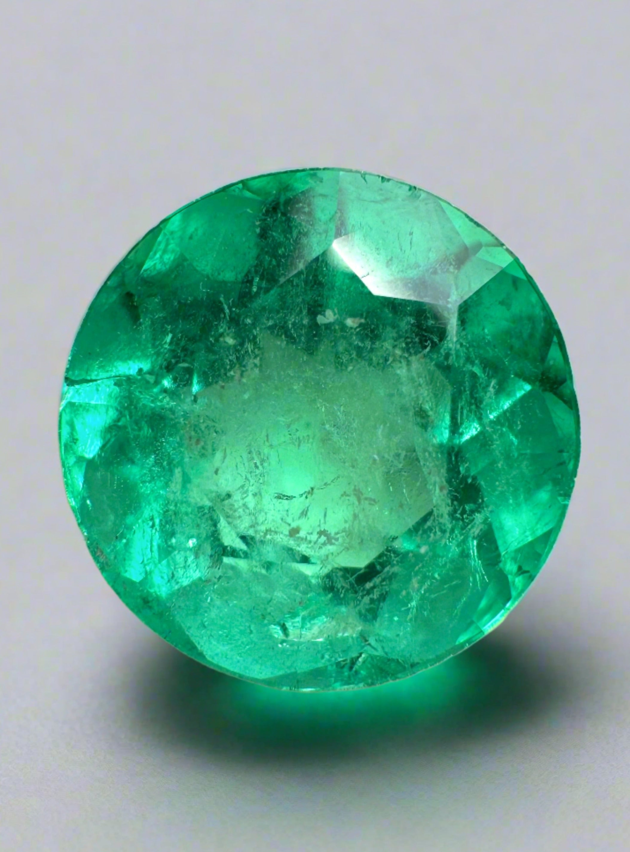 Vibrant green 3.79 carat natural round Colombian emerald loose gemstone with a bright, glossy surface and rich color.