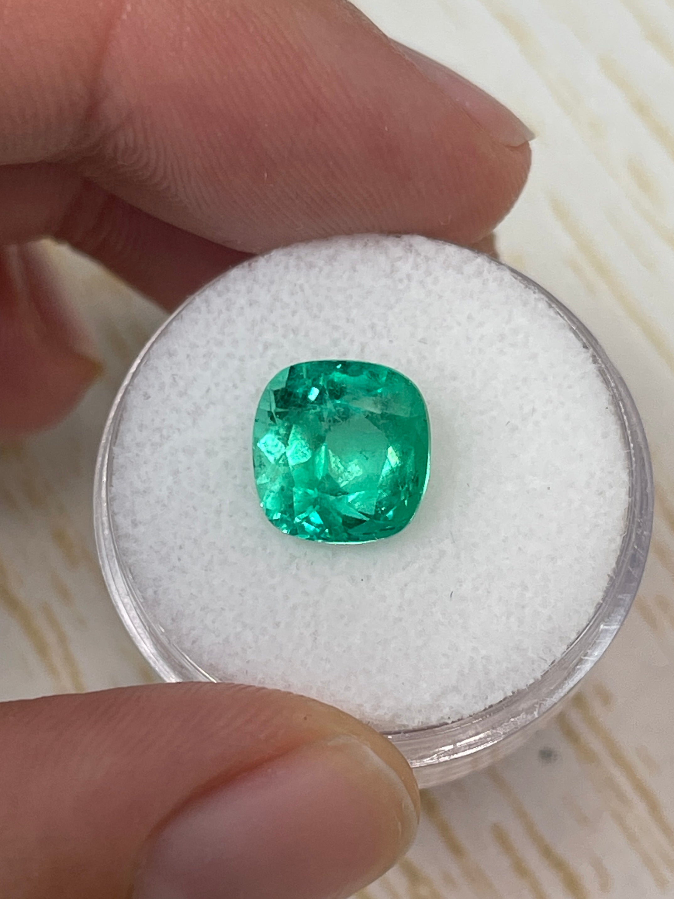 Bright yellowish green 3.85 carat natural Colombian emerald in cushion cut, showcasing vibrant color and clarity.