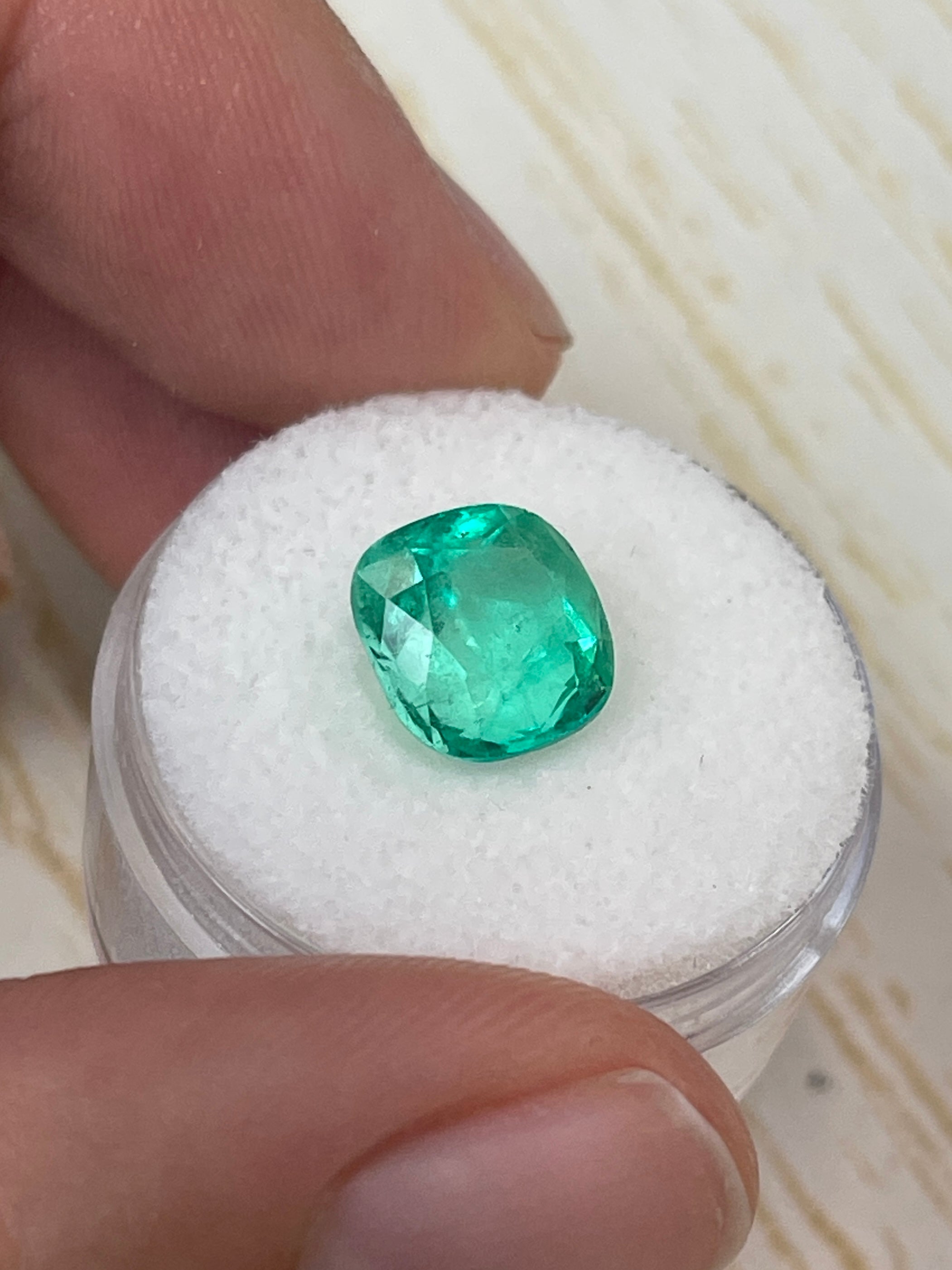 Bright yellowish green 3.85 carat natural Colombian emerald in cushion cut, showcasing vibrant color and clarity.