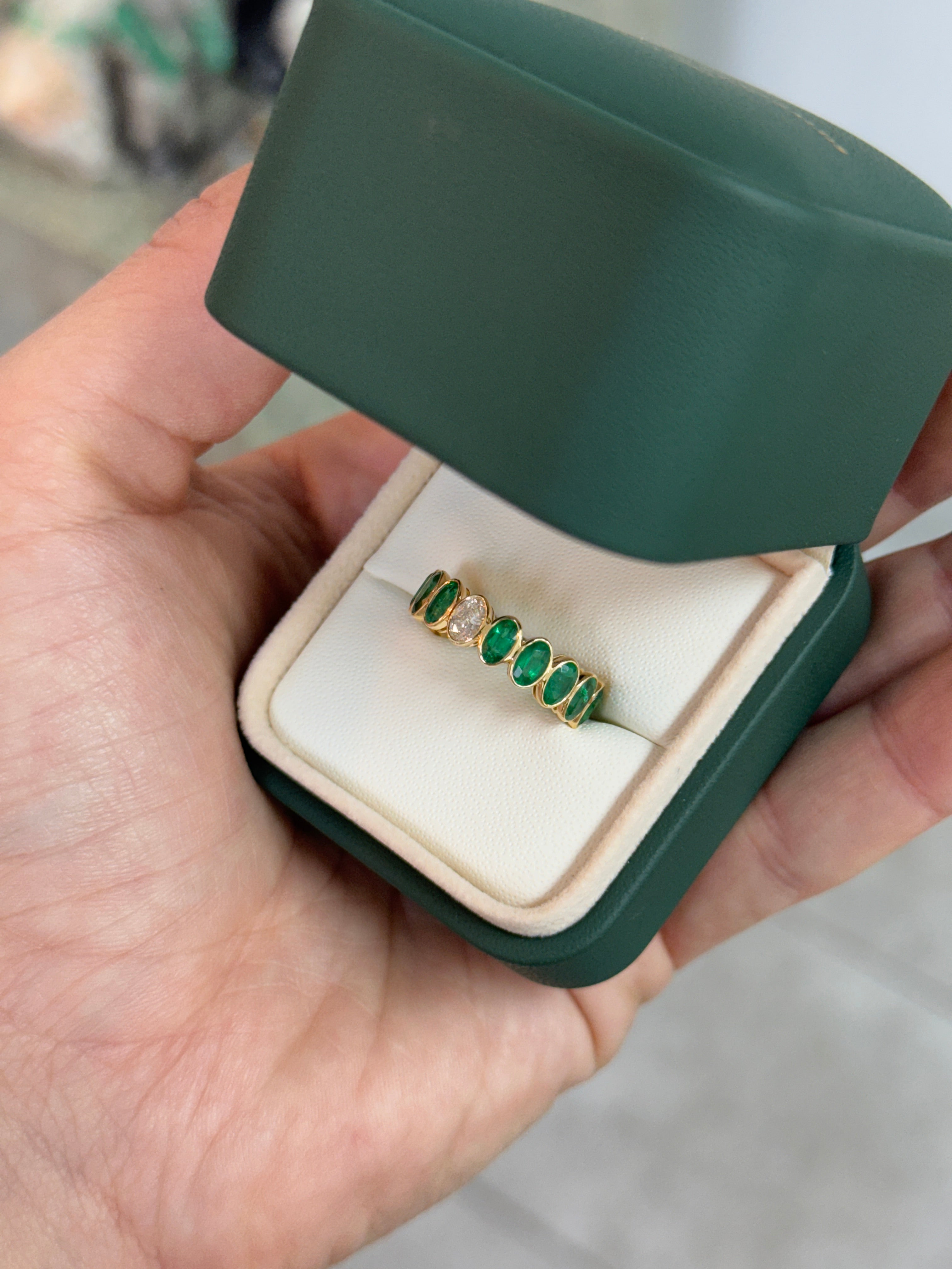 JR Colombian Emeralds 3.86tcw bezel set oval emerald and diamond eternity band in size 6.5, featuring alternating emeralds and diamonds.