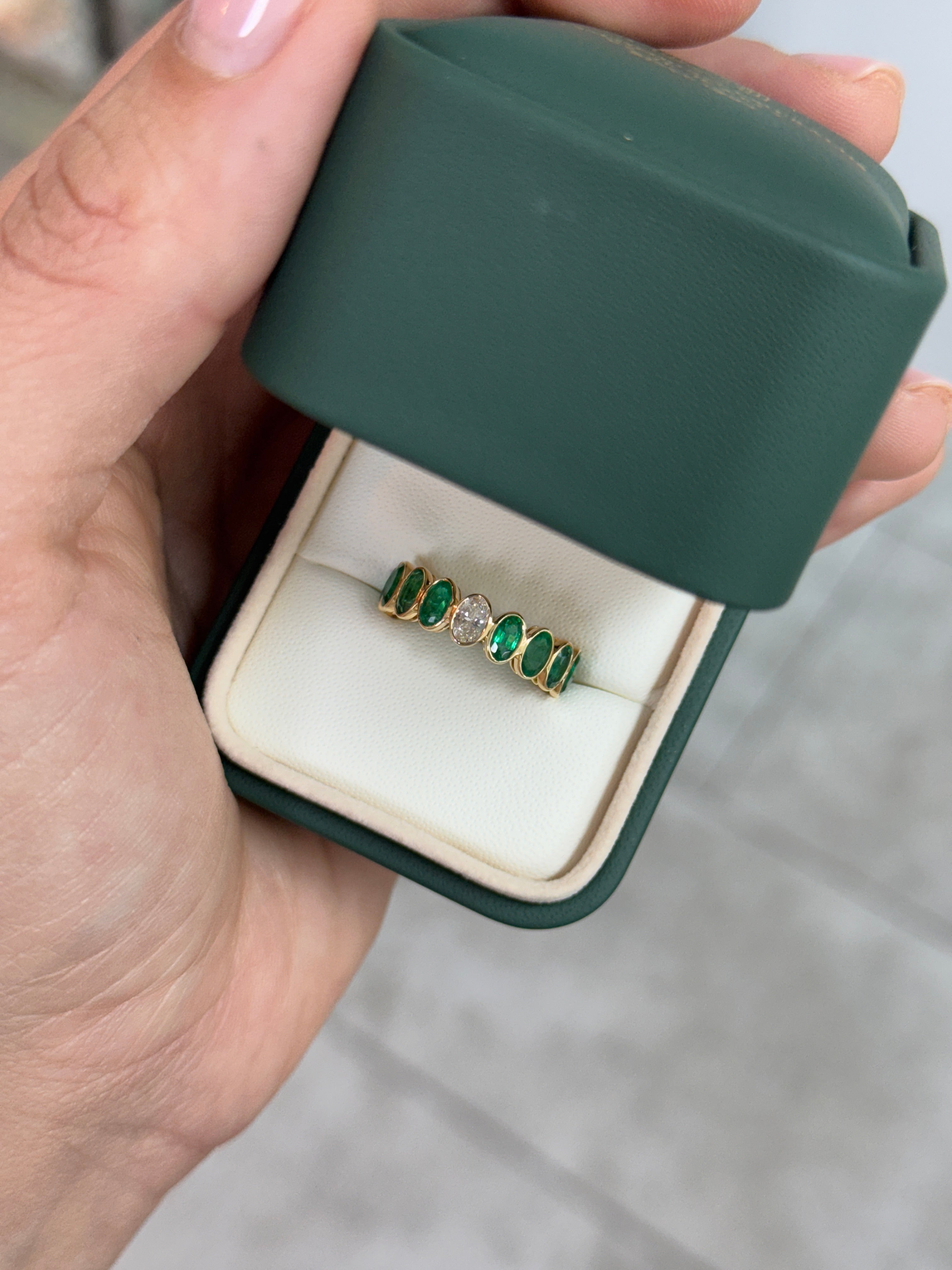 Bezel set oval emerald and diamond eternity band by JR Colombian Emeralds, 3.86tcw, size 6.5, featuring alternating gemstones.