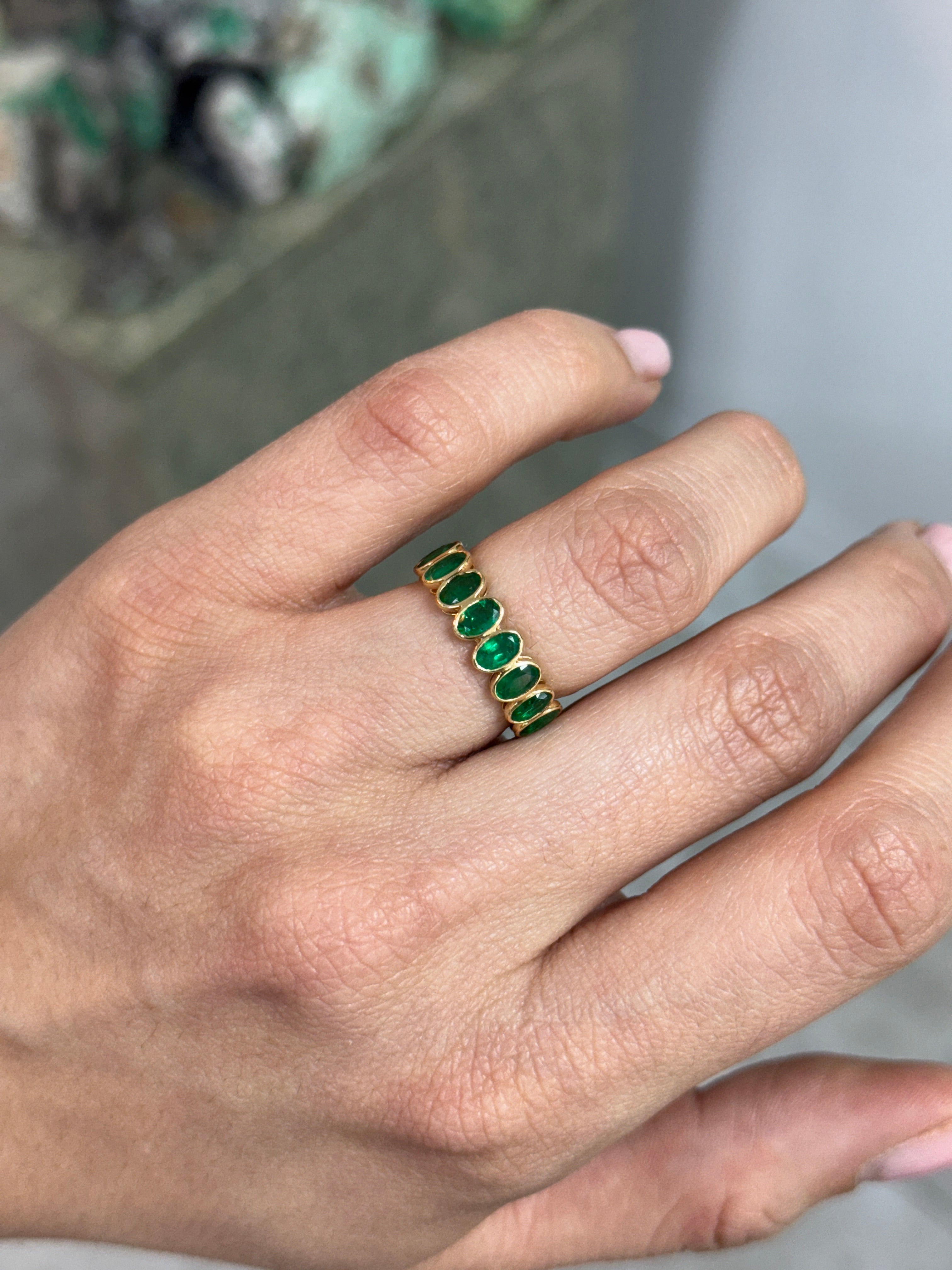 JR Colombian Emeralds 3.86ctw bezel set oval emerald and diamond eternity band in size 6.5, showcasing fine jewelry craftsmanship.