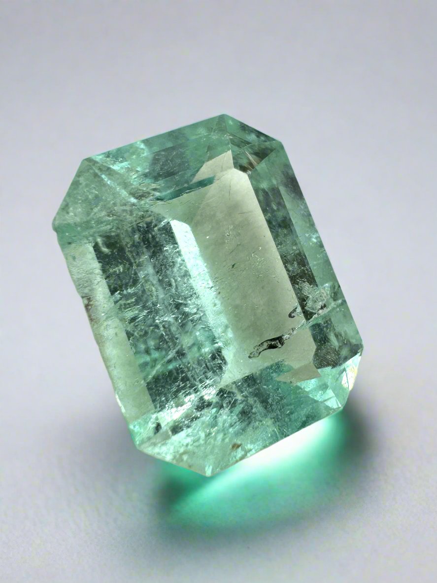 4.06 carat light green Colombian emerald loose gemstone with natural freckles, cut in a classic emerald shape, by JR Colombian Emeralds.