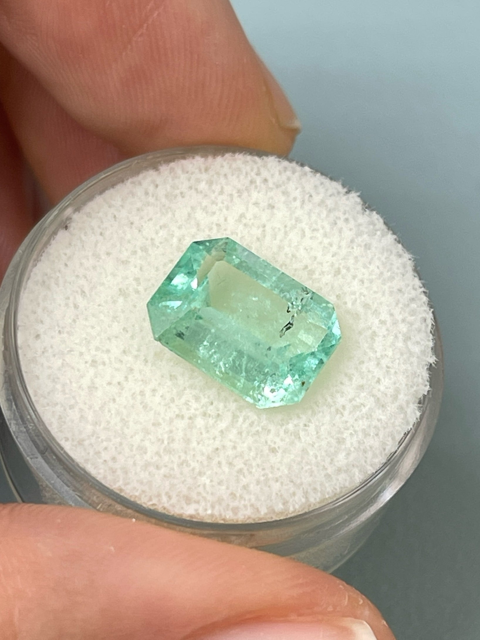 Natural 4.06 carat light green Colombian emerald loose gemstone, 11x9 mm classic emerald cut with natural freckles, from JR Colombian Emeralds.