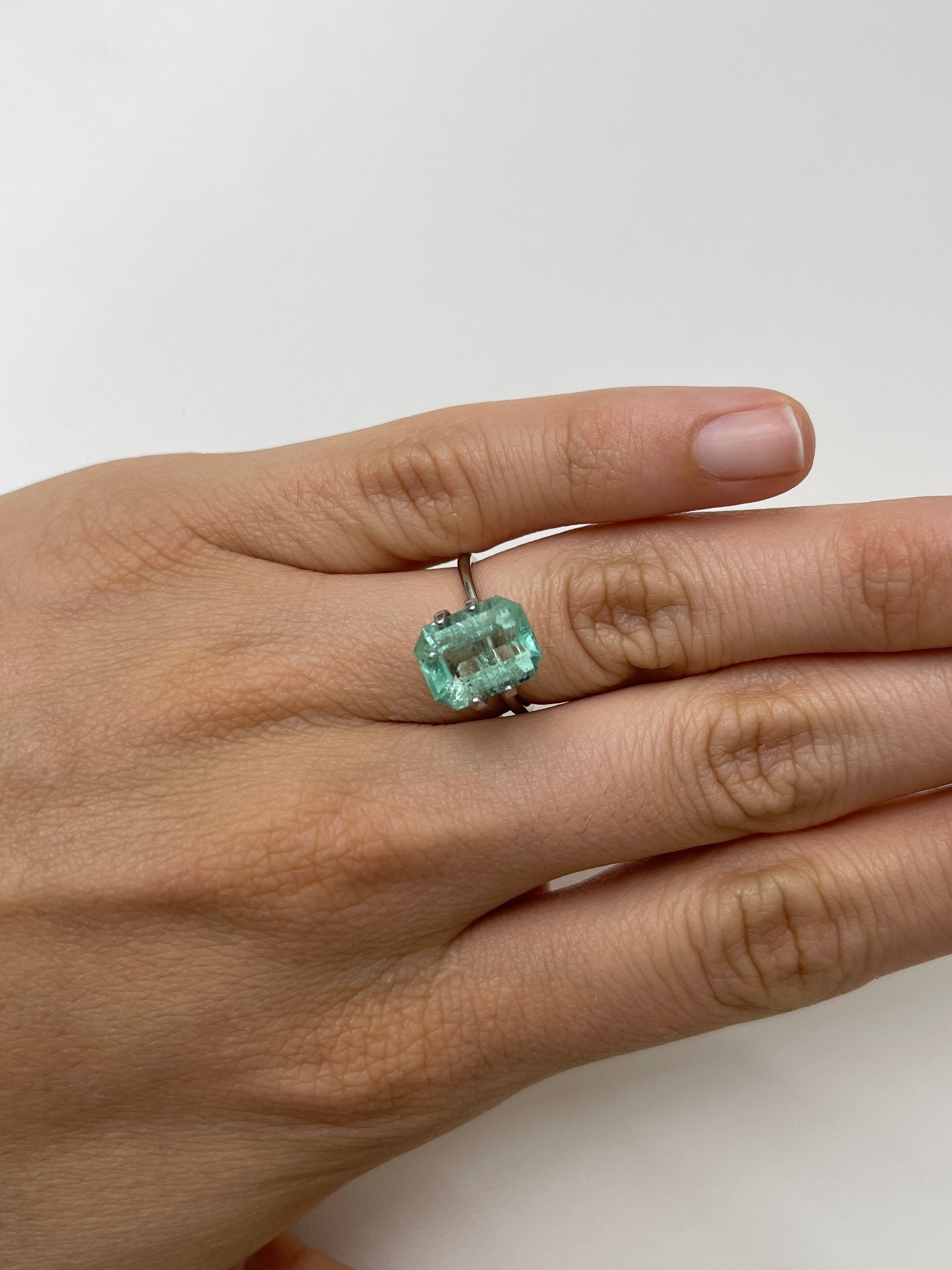 Light green 4.06 carat Colombian emerald loose gemstone with classic emerald cut and natural freckled appearance by JR Colombian Emeralds